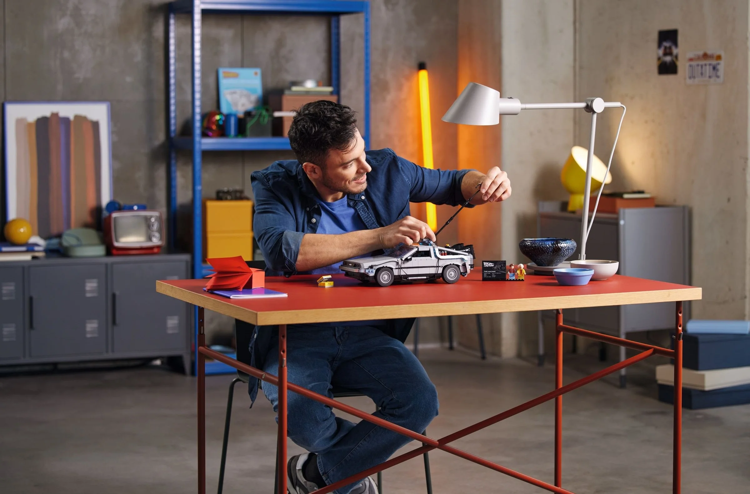 Bărbat asamblând DeLoreanul LEGO 10300, setul Mașina Timpului Back to the Future.