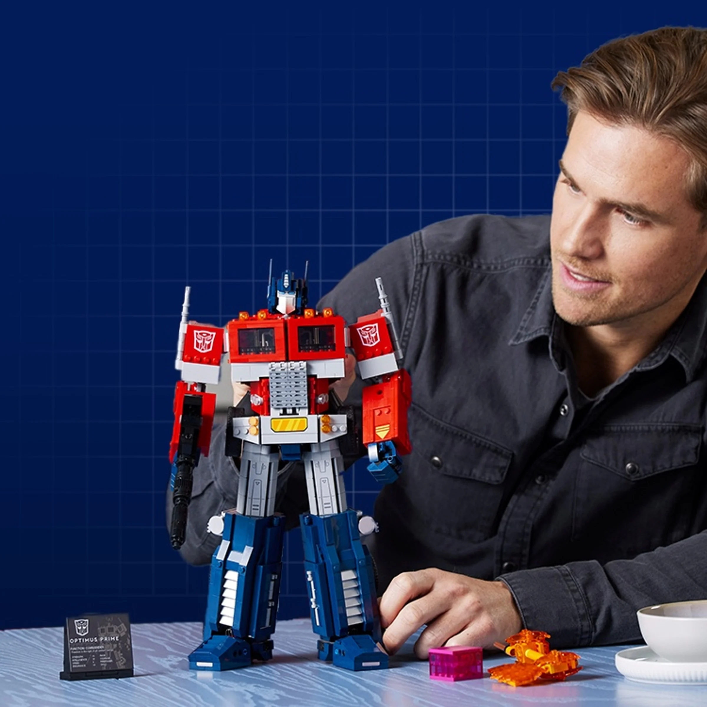 Optimus Prime LEGO 10302 prezentat cu un bărbat zâmbitor. Figurina e detaliată și colorată.
