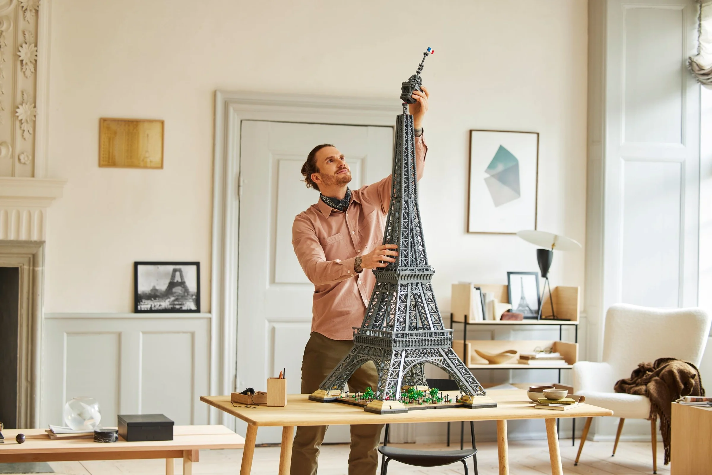 Bărbat montează vârful Turnului Eiffel LEGO, model masiv și detaliat. O construcție impresionantă!