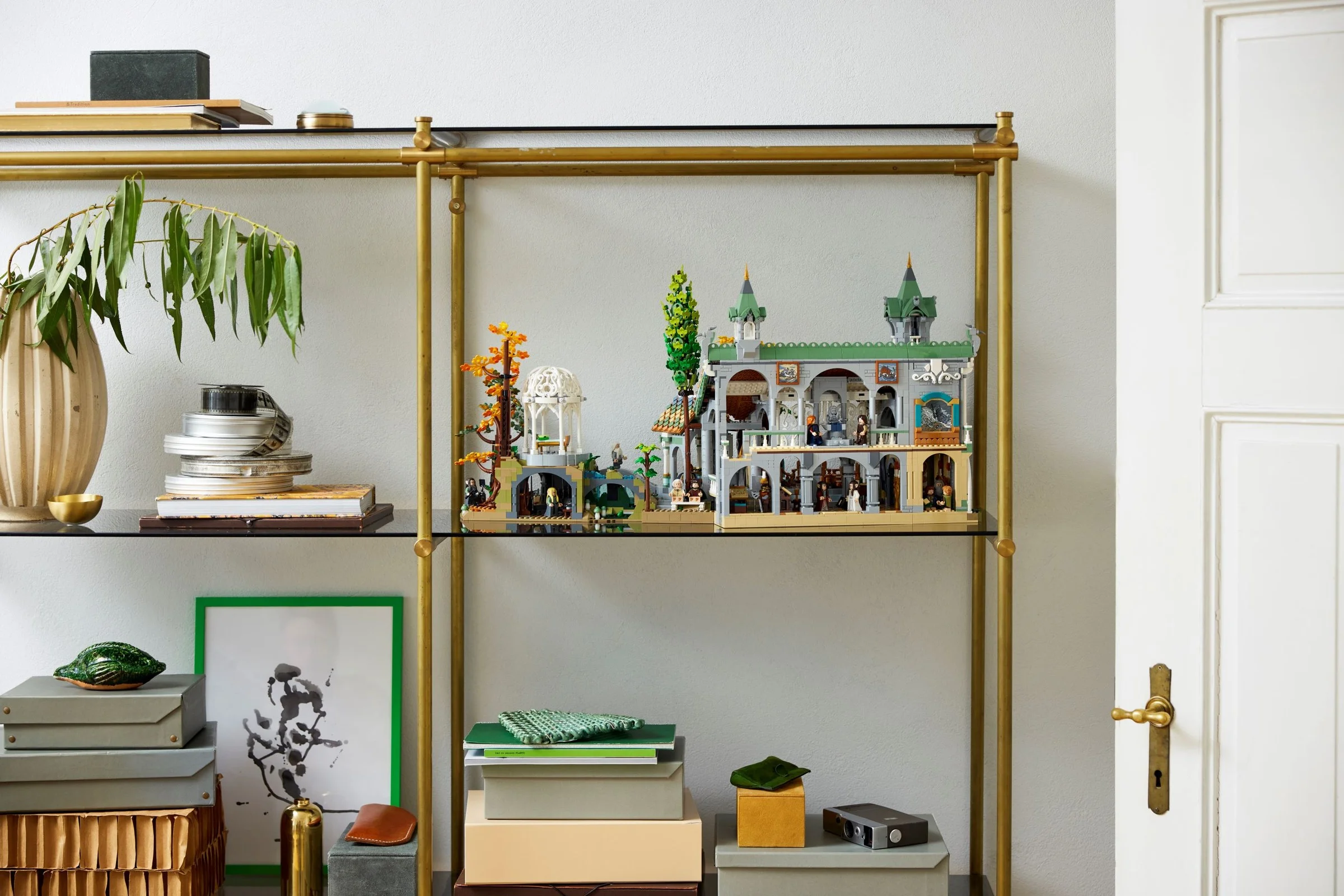 Rivendell LEGO 10316 pe raft, cu decor minimalist. Aspect elegant și detaliat al modelului.