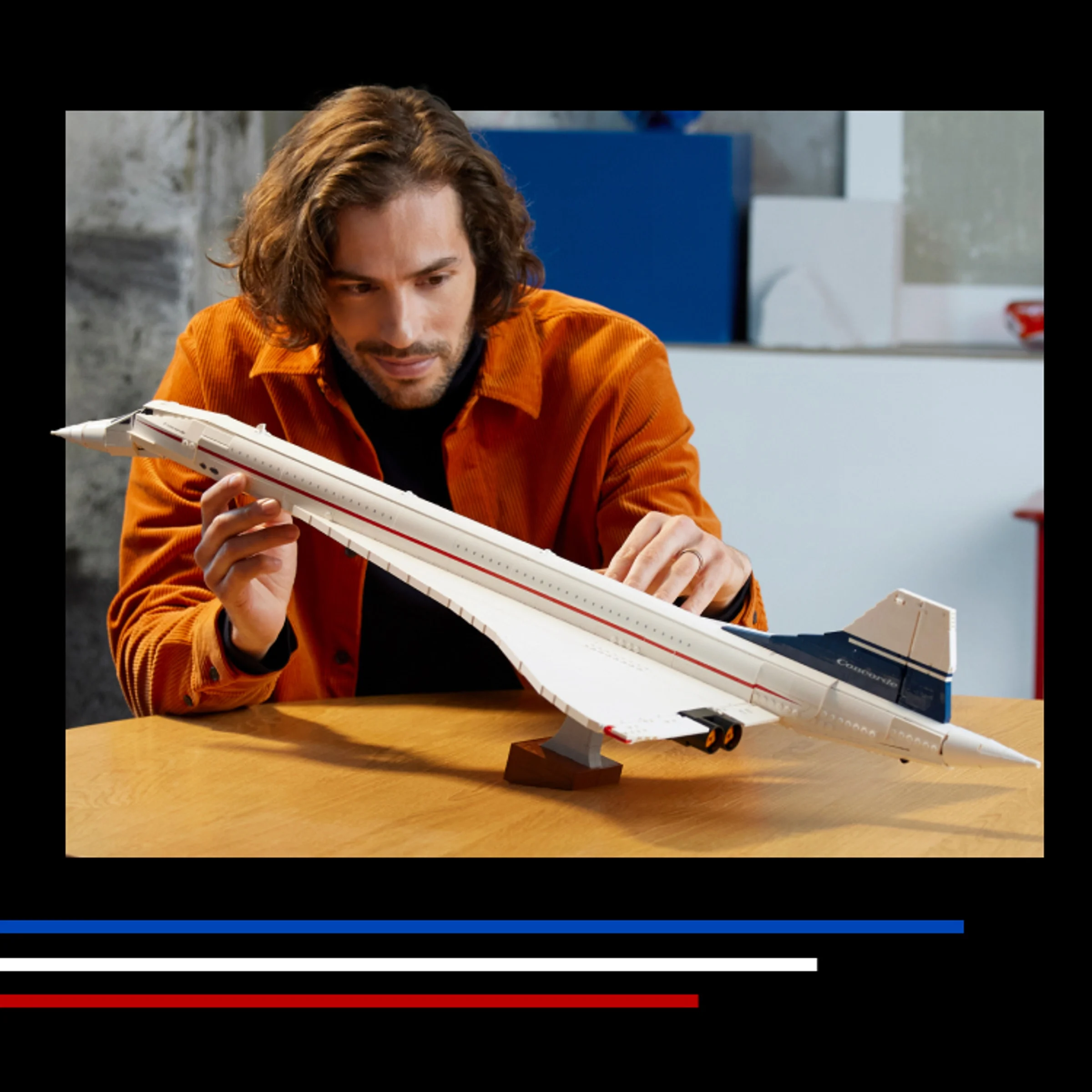 Bărbat admirând modelul LEGO Concorde, o replică detaliată și elegantă. 