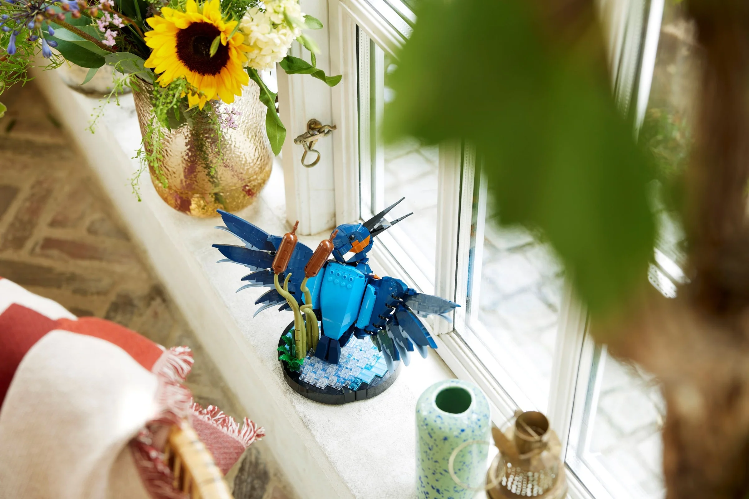 Modelul LEGO 10331 Kingfisher, prezentat pe pervazul unei ferestre, cu detalii realiste.