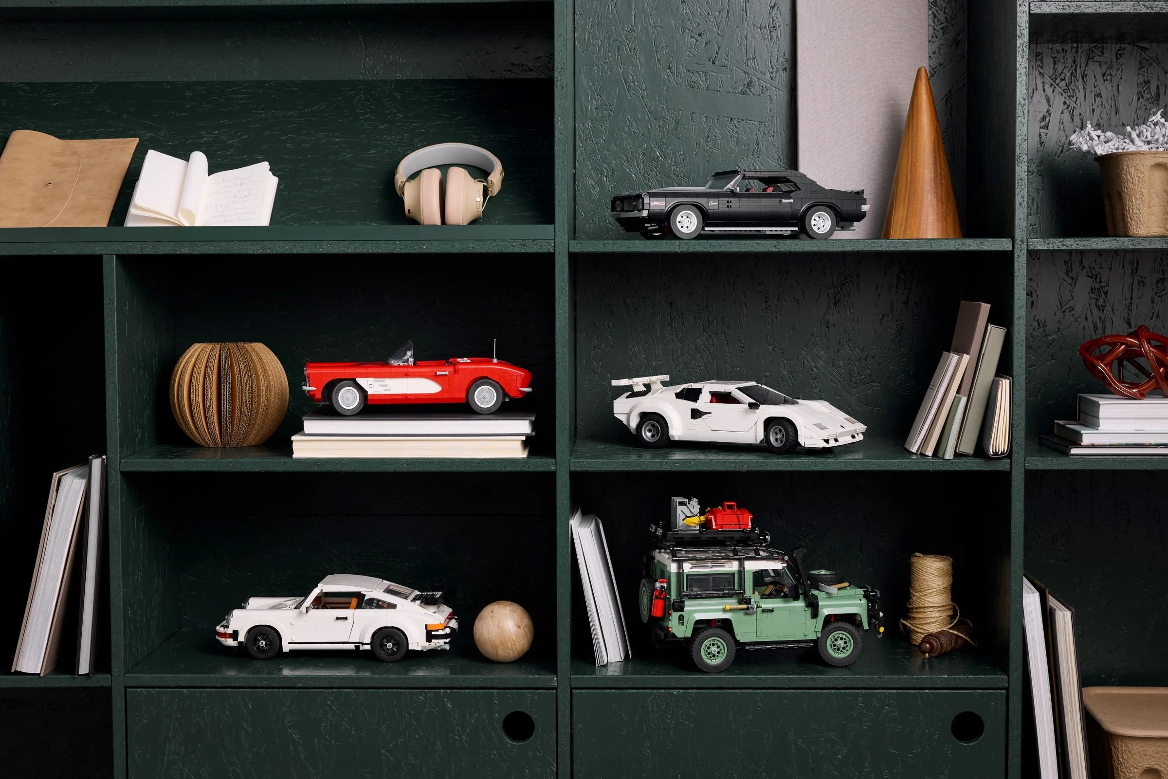 Un Lamborghini Countach alb LEGO, printre alte modele LEGO pe o etajeră verde.