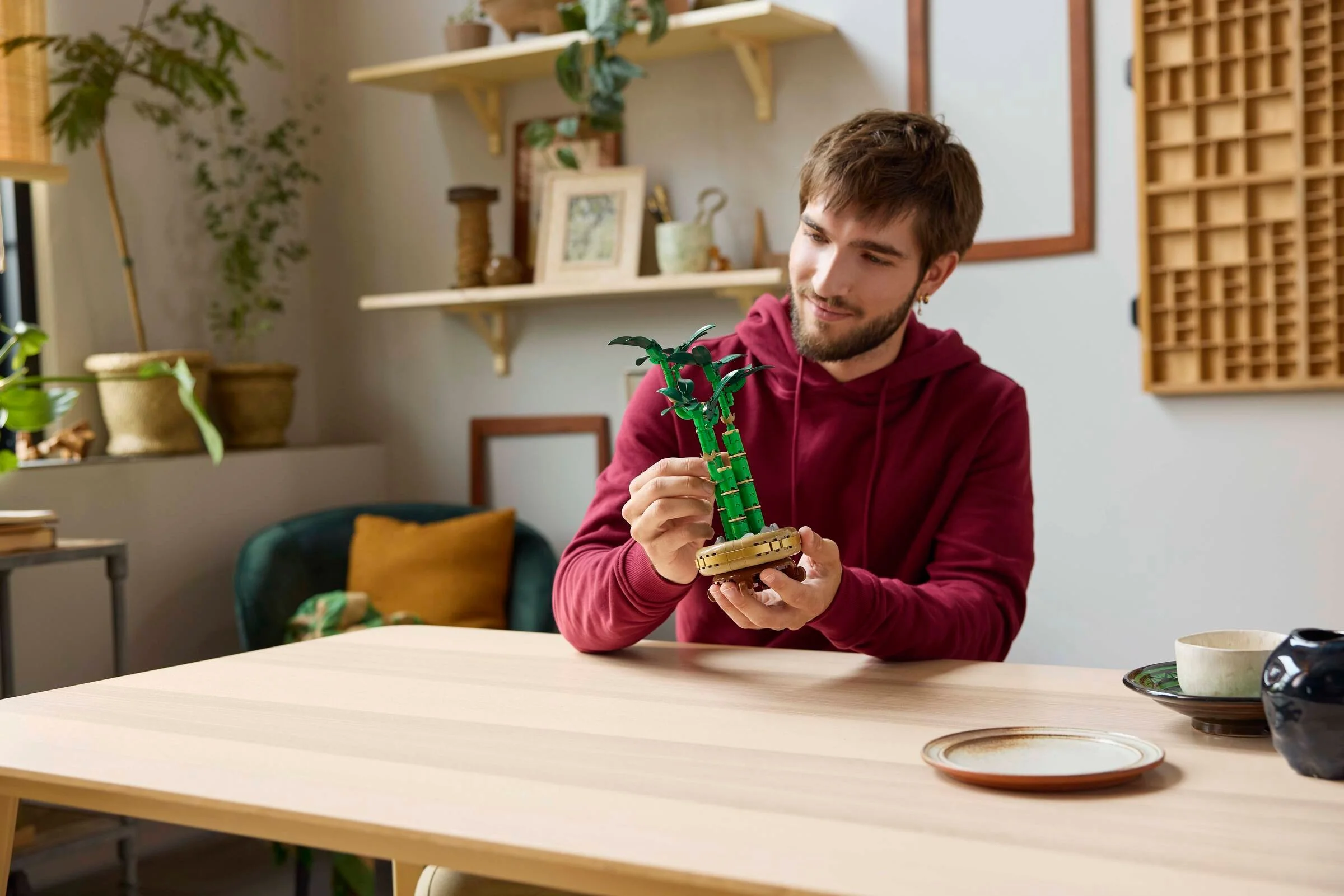 Un tânăr admiră setul LEGO Lucky Bamboo, ținându-l în mâini cu atenție.