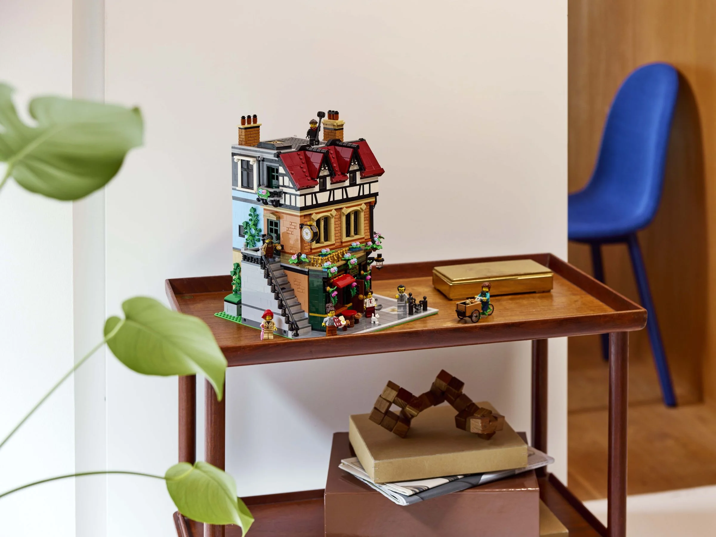 Setul LEGO 10350 Tudor Corner, prezentat pe o măsuță. Aspect viu, cu minifigurine și detalii arhitecturale.