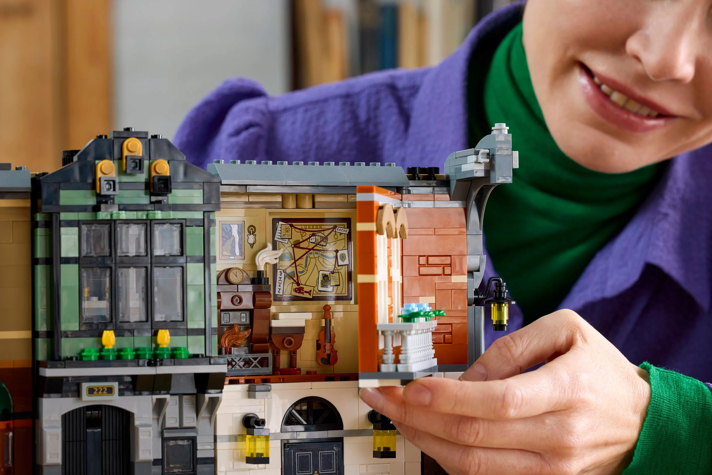 O persoană asamblează Book Nook-ul LEGO Sherlock Holmes, arătând detalii interioare.