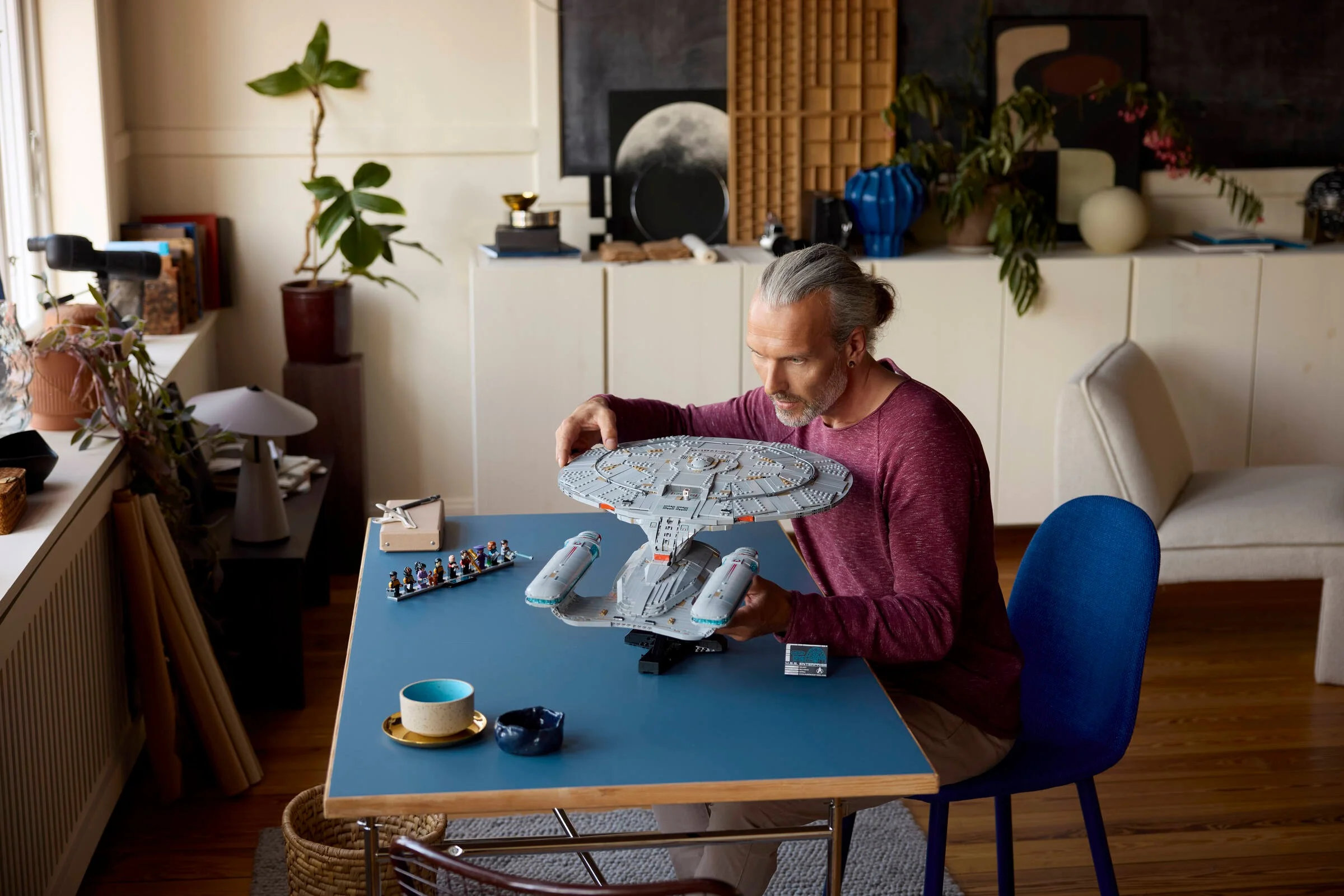 Un adult construiește modelul LEGO Star Trek U.S.S. Enterprise NCC-1701-D. Model detaliat.