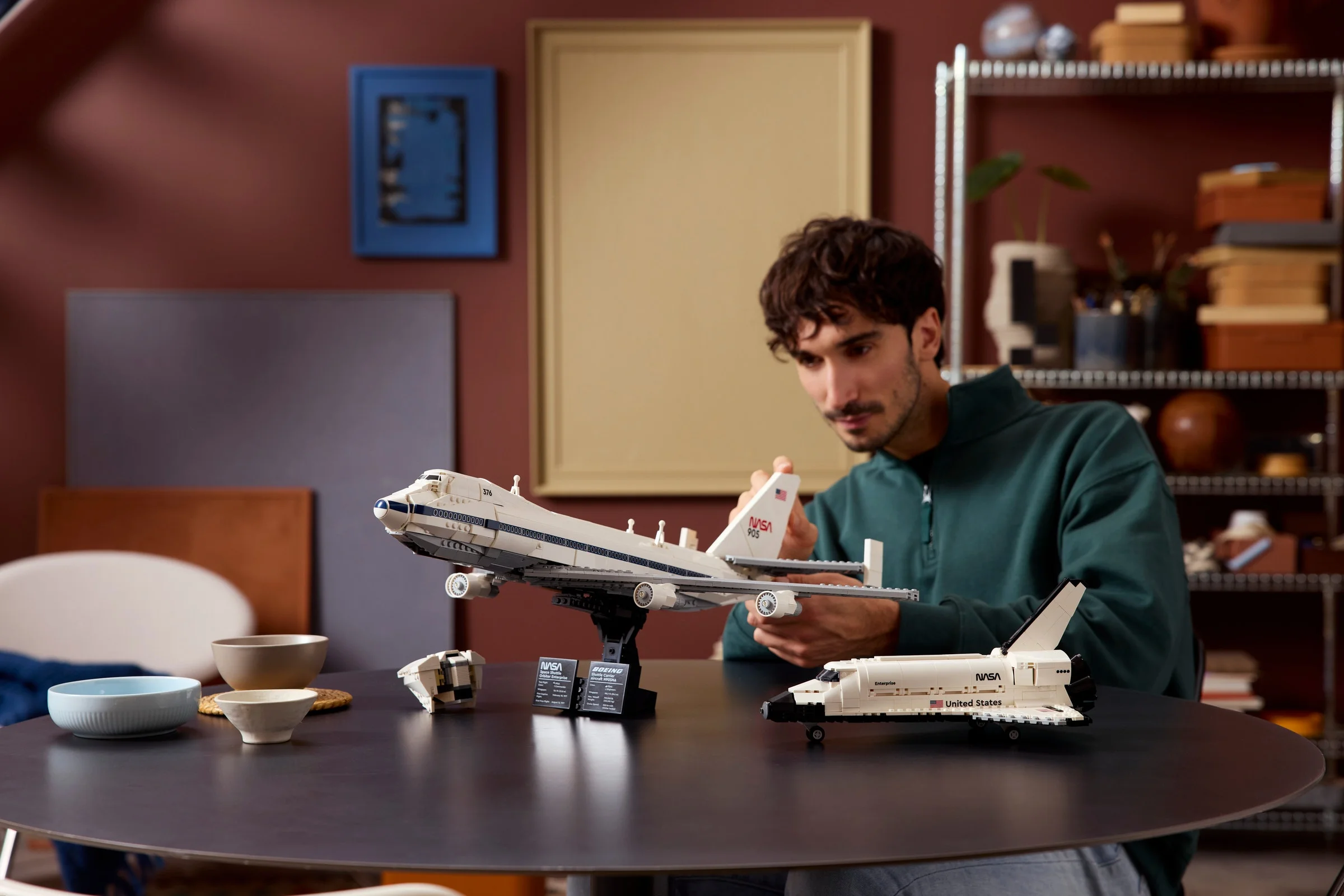 Un bărbat inspectează atent modelul LEGO al Boeing Shuttle Carrier Aircraft.