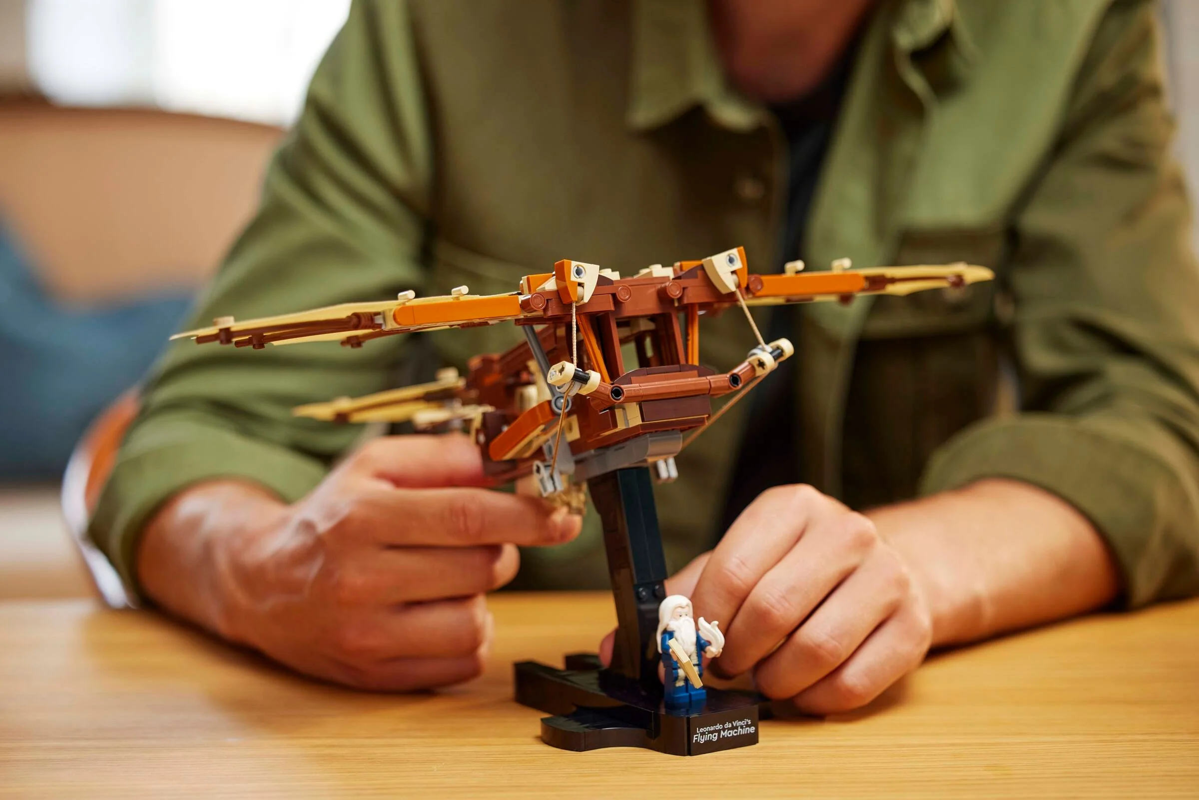 Imagine detaliată cu mașina de zbor LEGO, minifigurina și mâini care o țin.