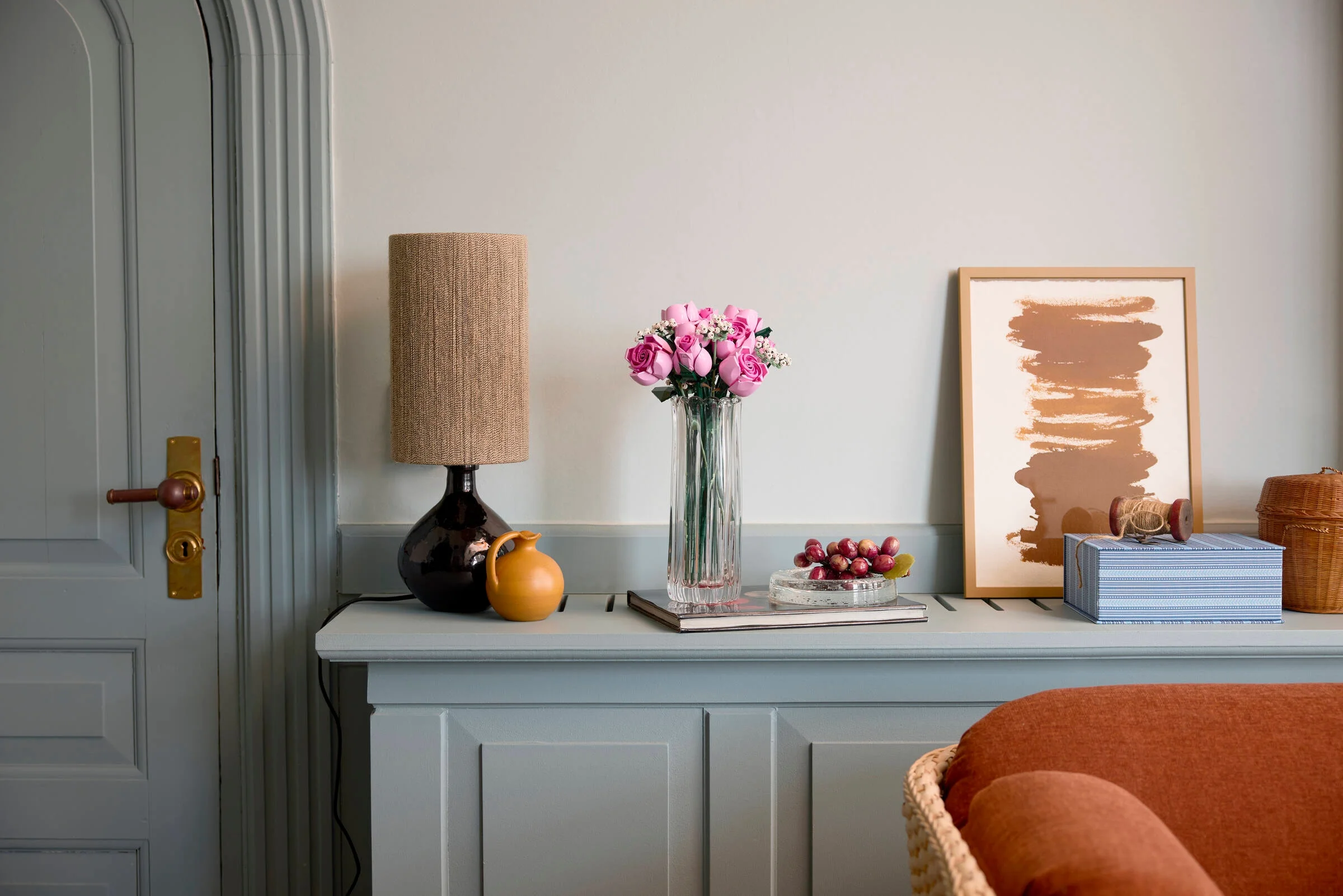 Buchetul de trandafiri roz LEGO 10374 într-o vază, ca decor într-o cameră.