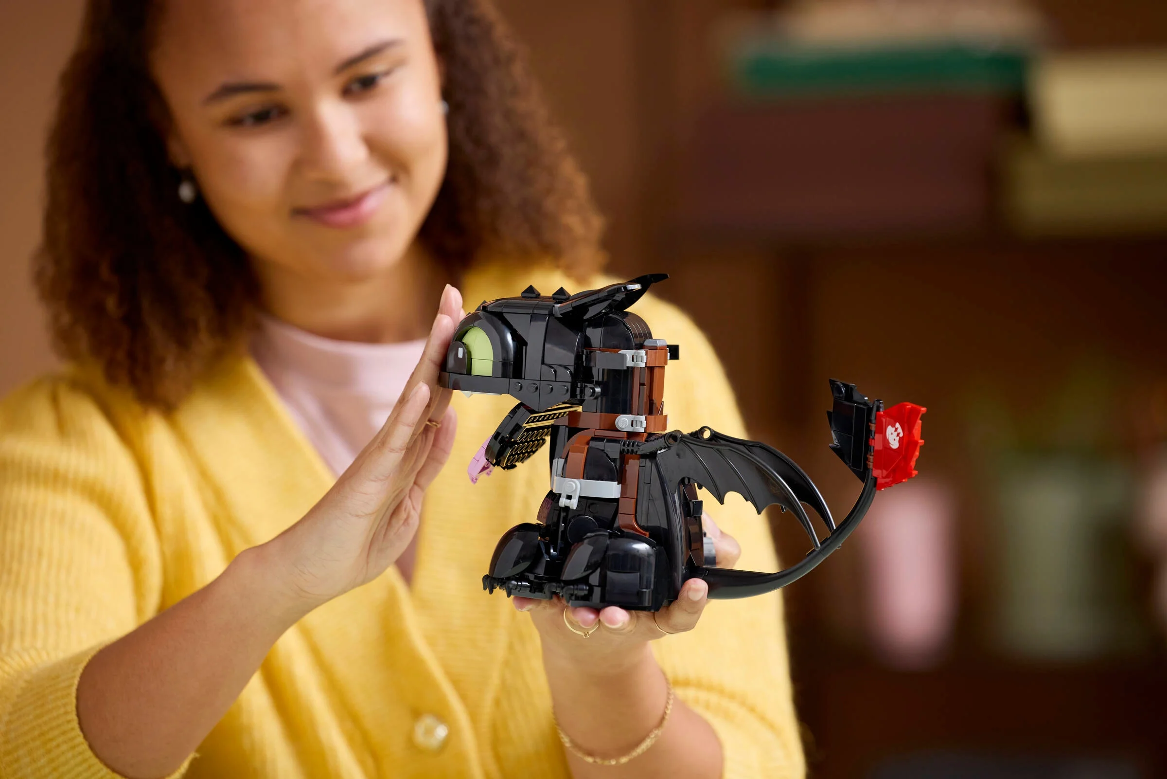 O tânără admiră modelul LEGO Toothless. Un cadou minunat pentru fani.