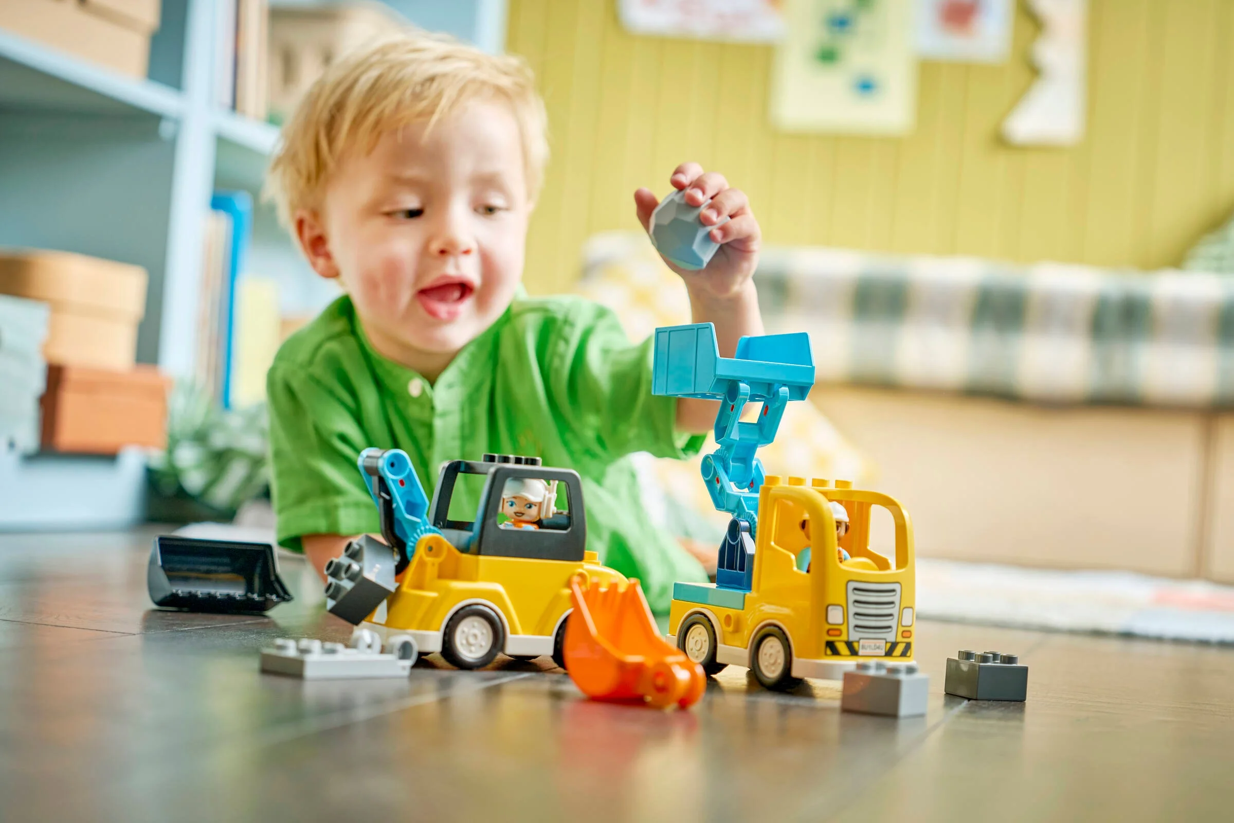 Băiat jucându-se cu vehiculele Duplo. Joacă creativă cu jucării sigure și colorate.