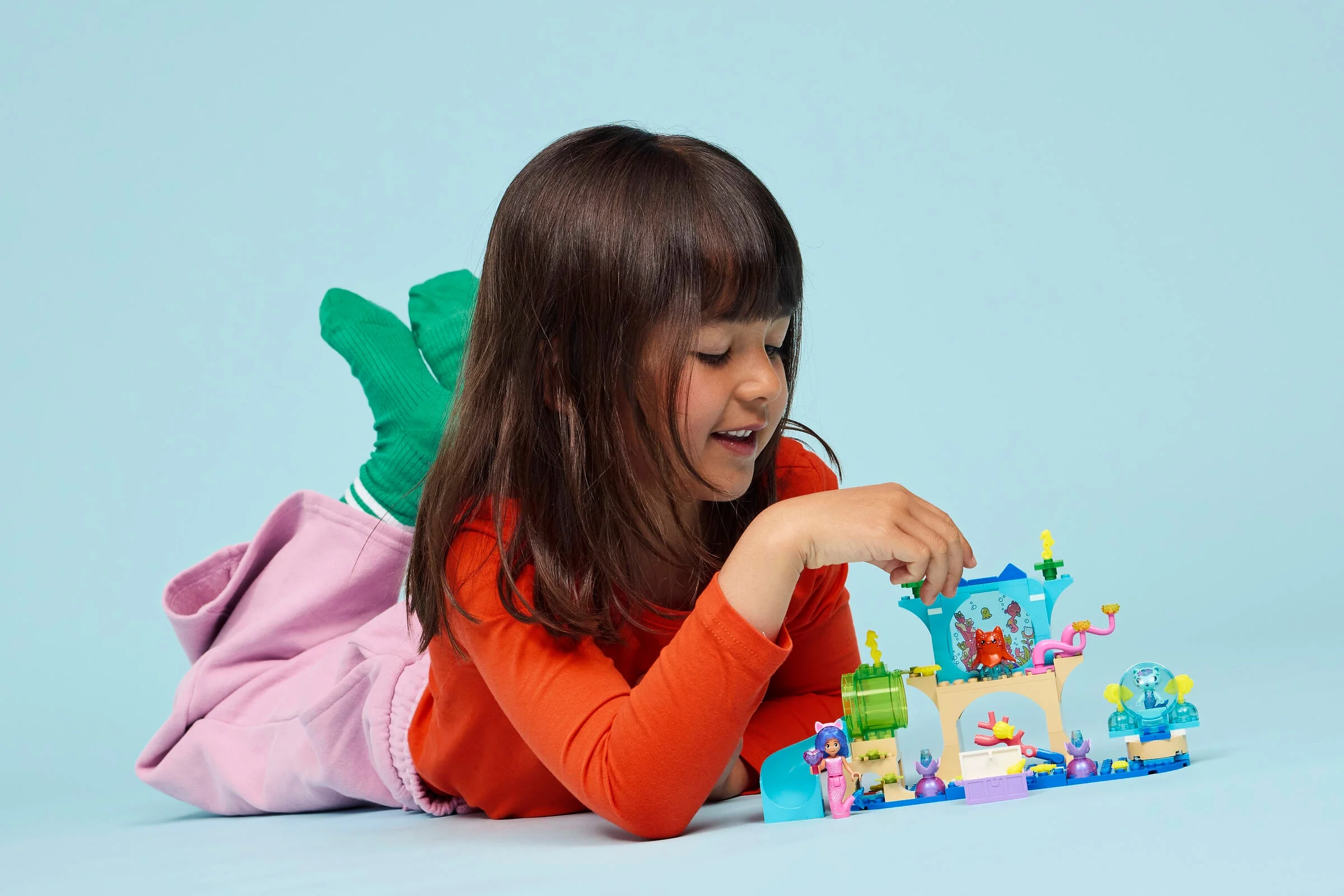 Fetiță se joacă cu setul LEGO Gabby's Aquarium Adventure, explorând lumea subacvatică creativă.