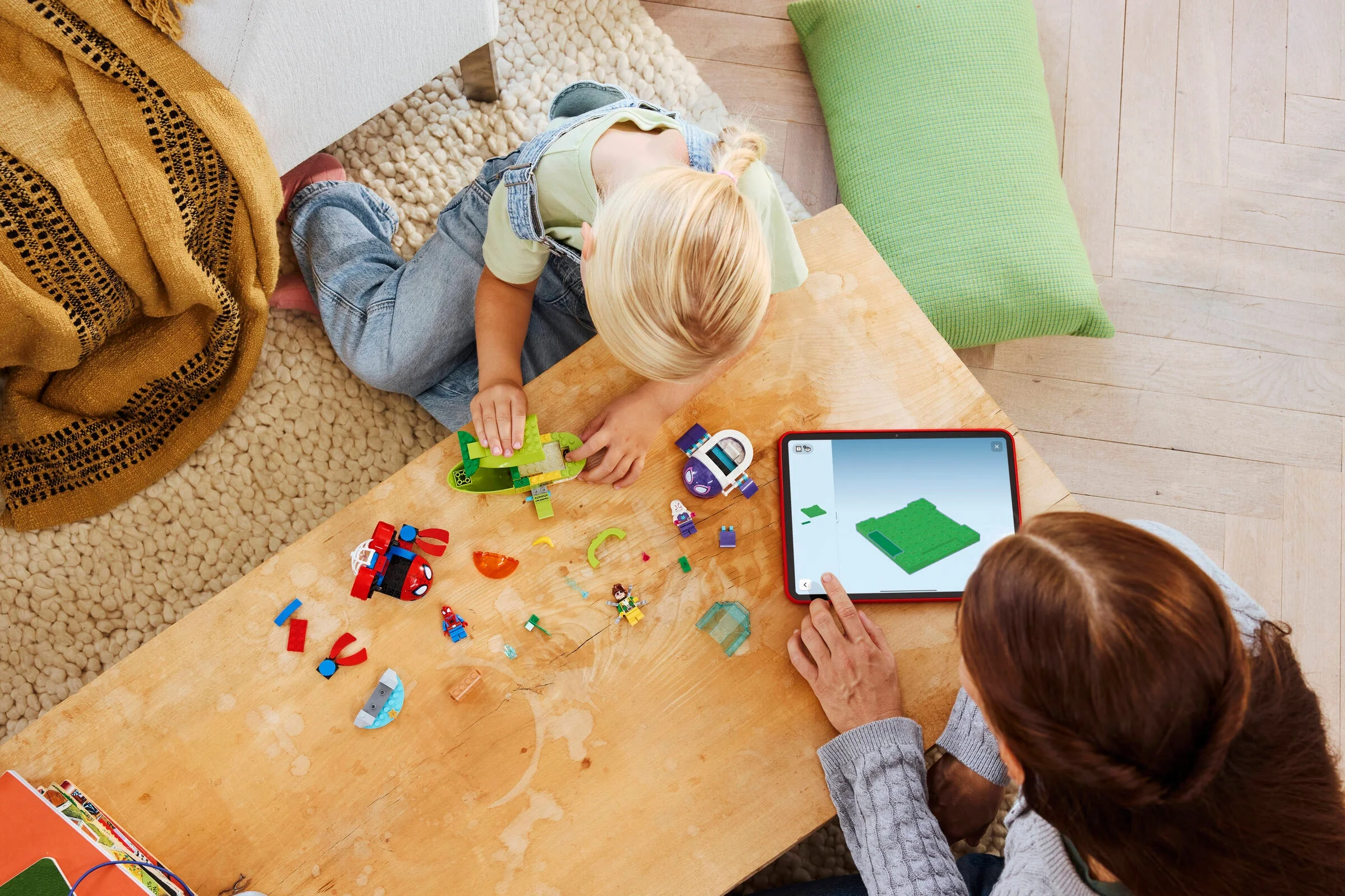 Copil construind setul LEGO Spidey 11207 cu ajutorul instrucțiunilor digitale pe tabletă.