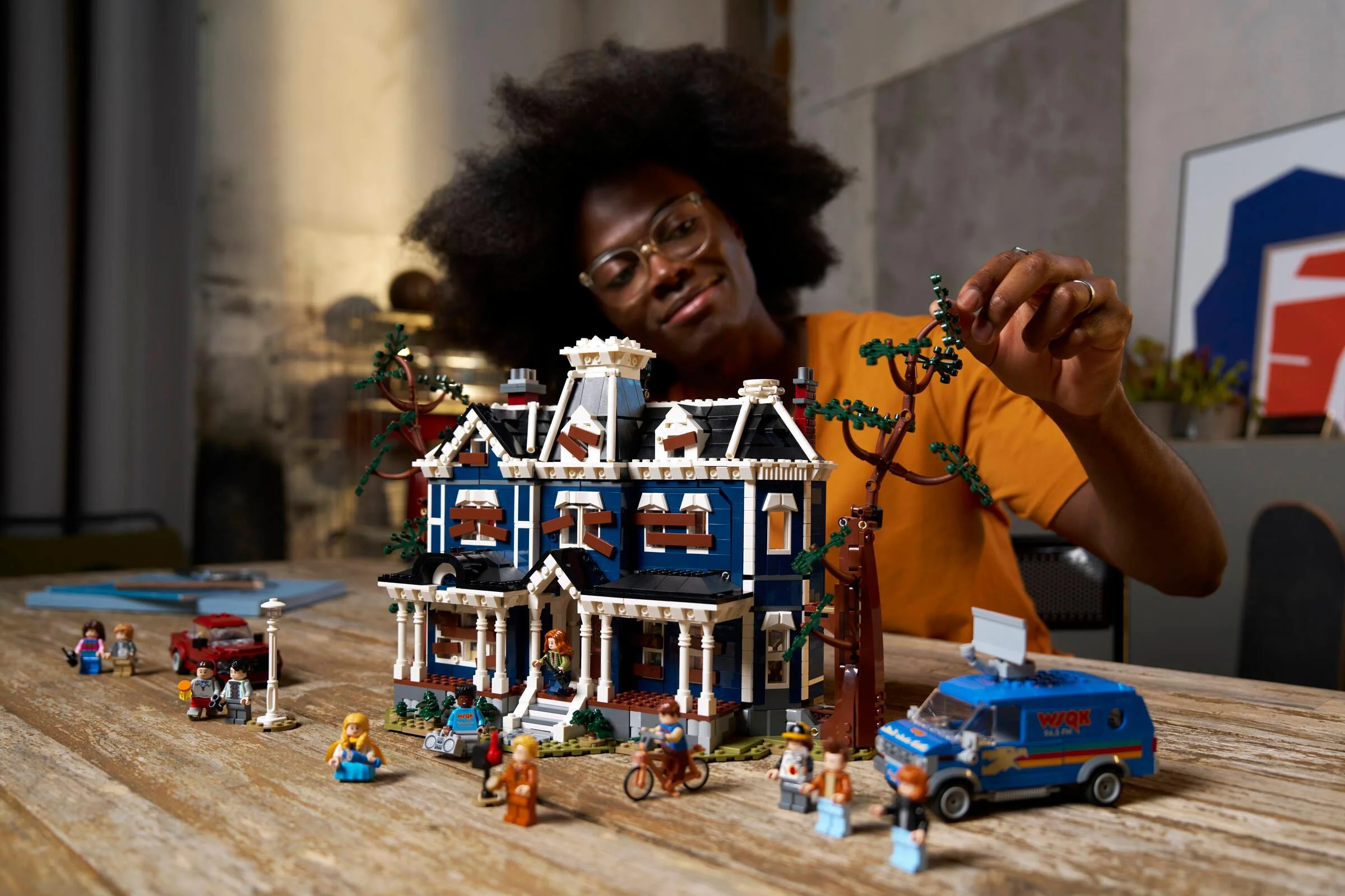 Imagine cu casa Creel din LEGO, cu o persoană adăugând o ramură de copac.