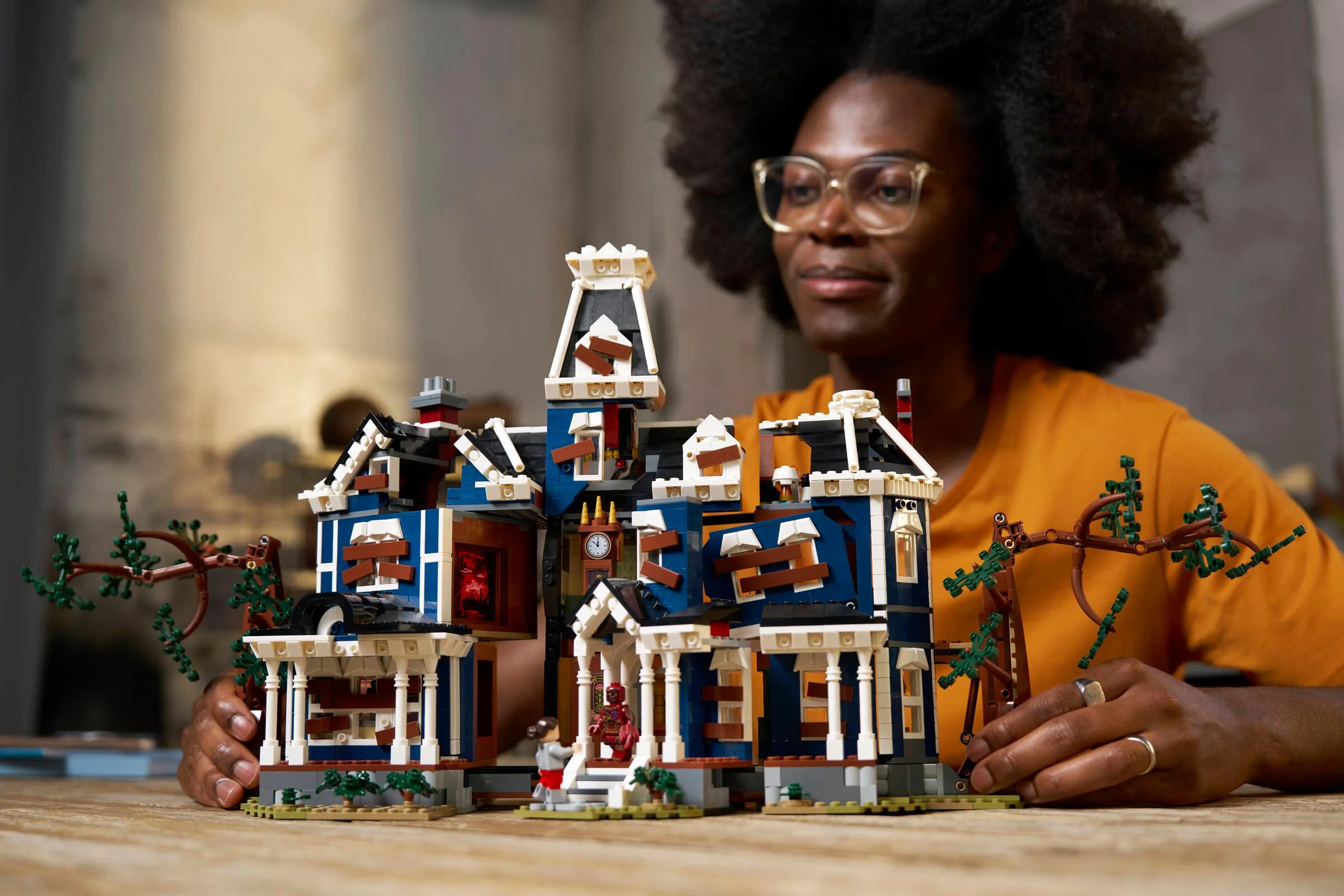 Persoană interacționând cu macheta LEGO Creel House din Stranger Things.