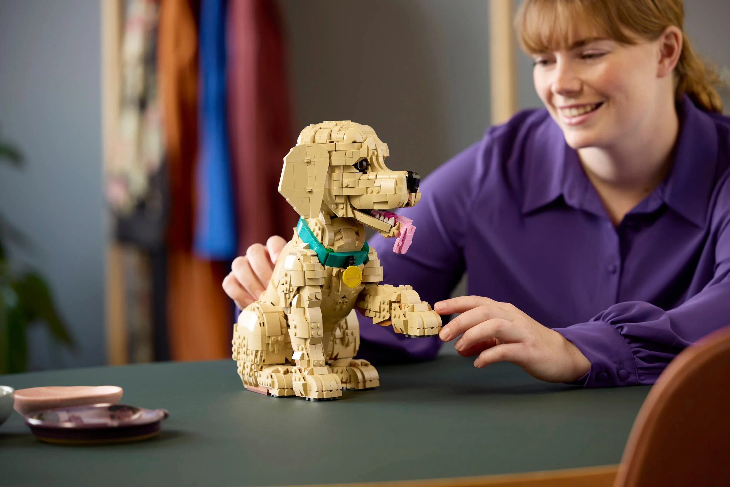Imagine cu cățelul Golden Retriever LEGO 11384, alături de o persoană zâmbitoare.