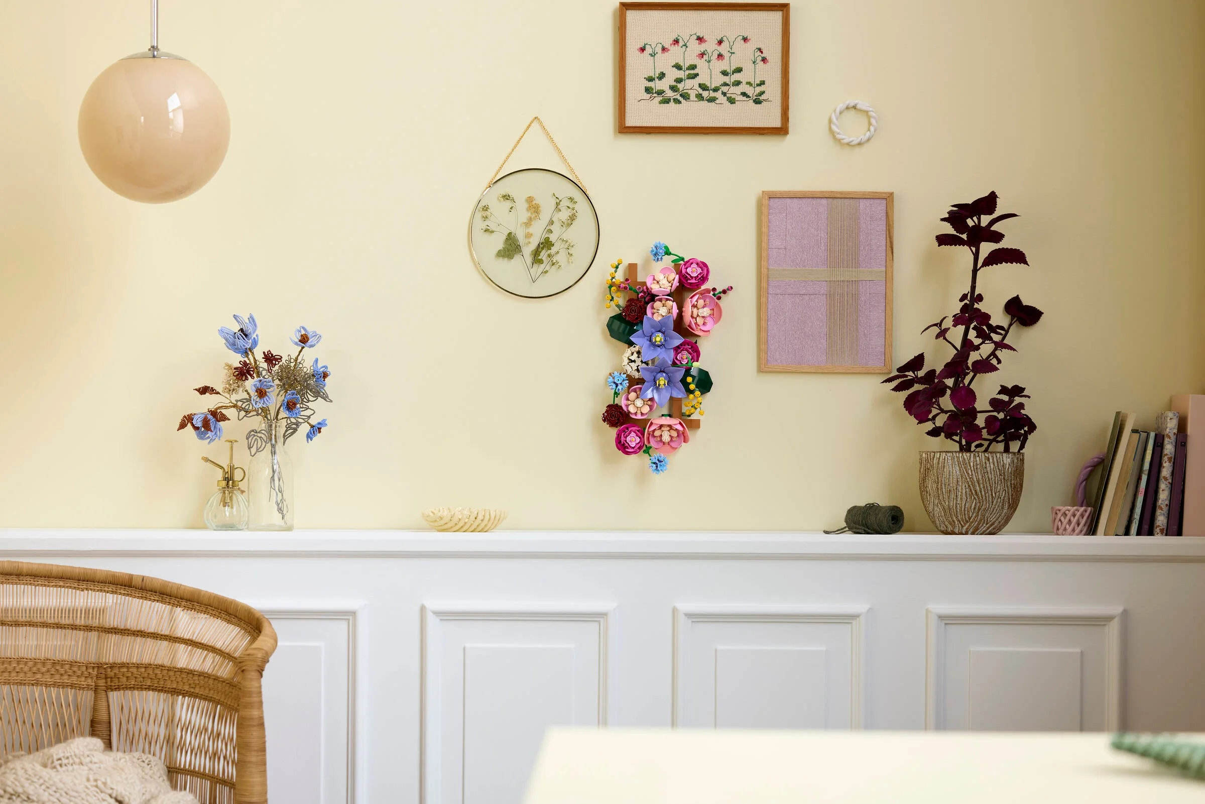 Un perete decorat cu flori LEGO, aranjamente florale și alte elemente decorative.