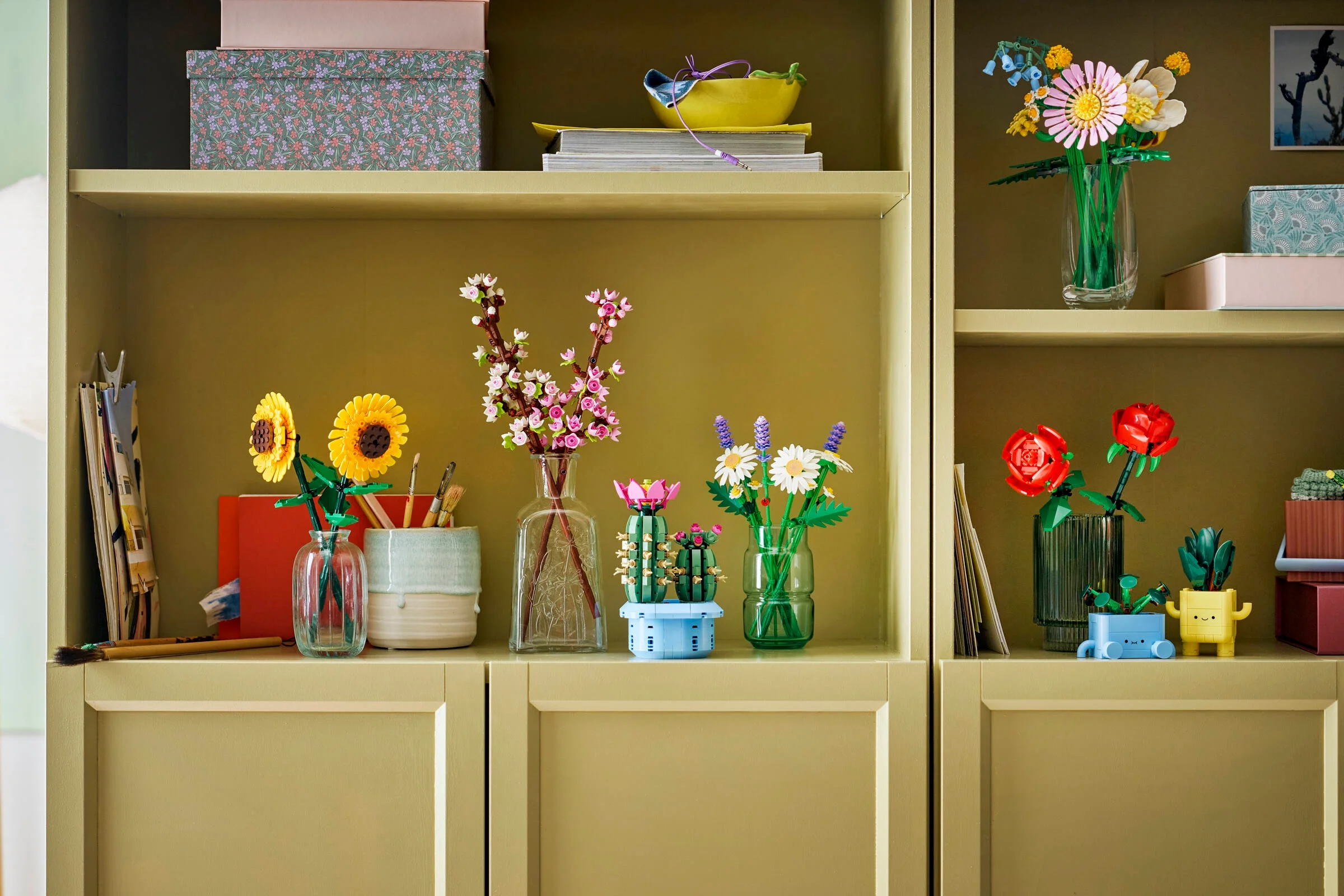 Diverse flori și plante LEGO Botanicals aranjate pe rafturi într-un decor casnic, viu colorat.