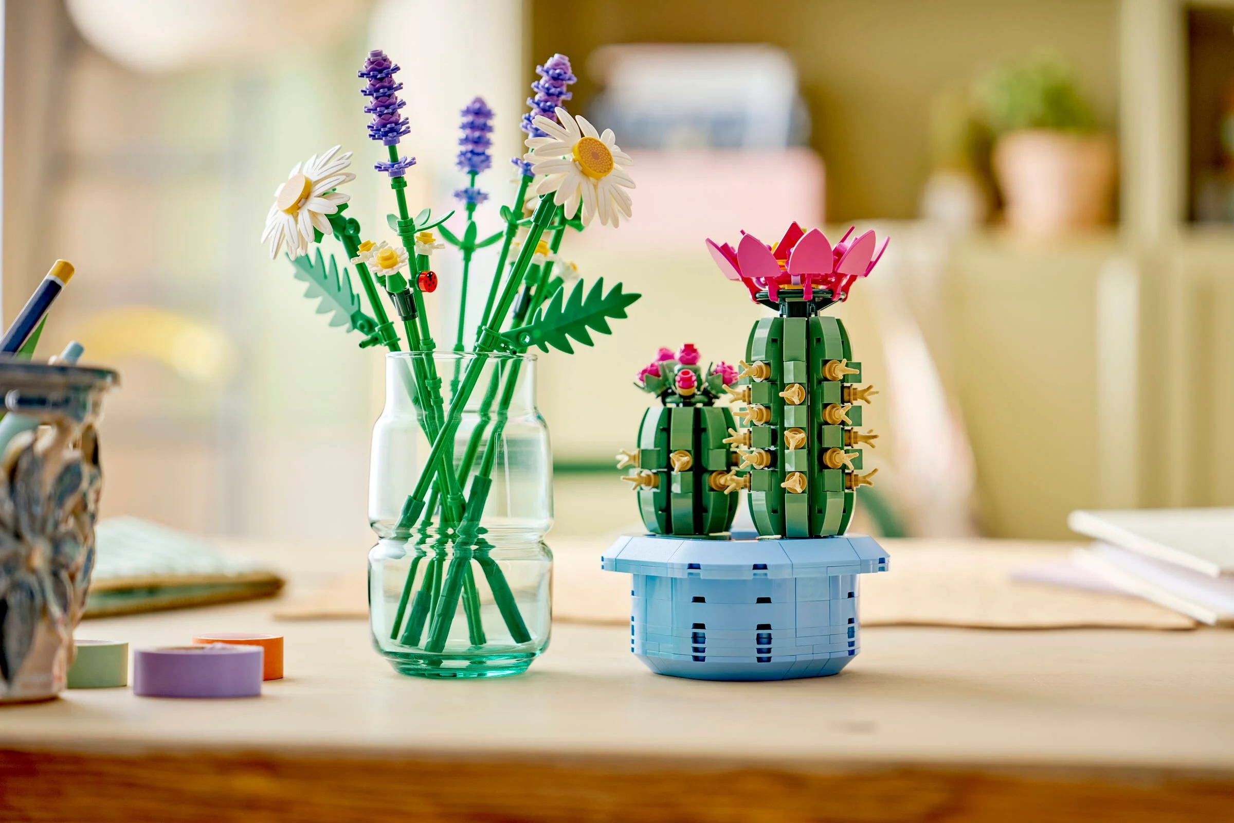 Aranjament floral LEGO cu cactuși și flori diverse într-un vas, ideal pentru decor.