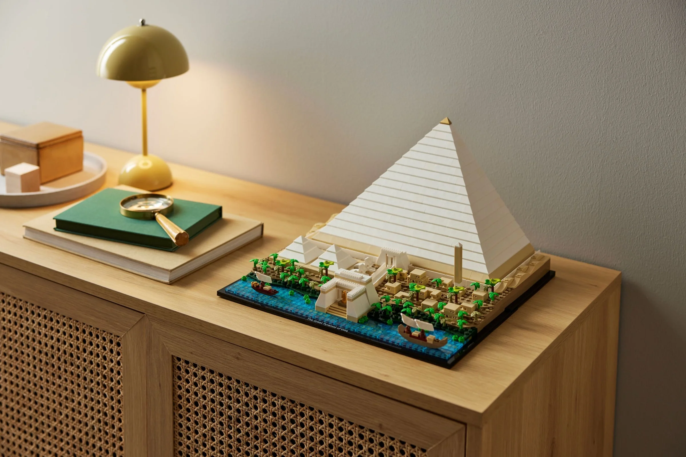 Modelul LEGO al Marii Piramide din Giza, expus pe o comodă, cu detalii fine. Arhitectură impresionantă.