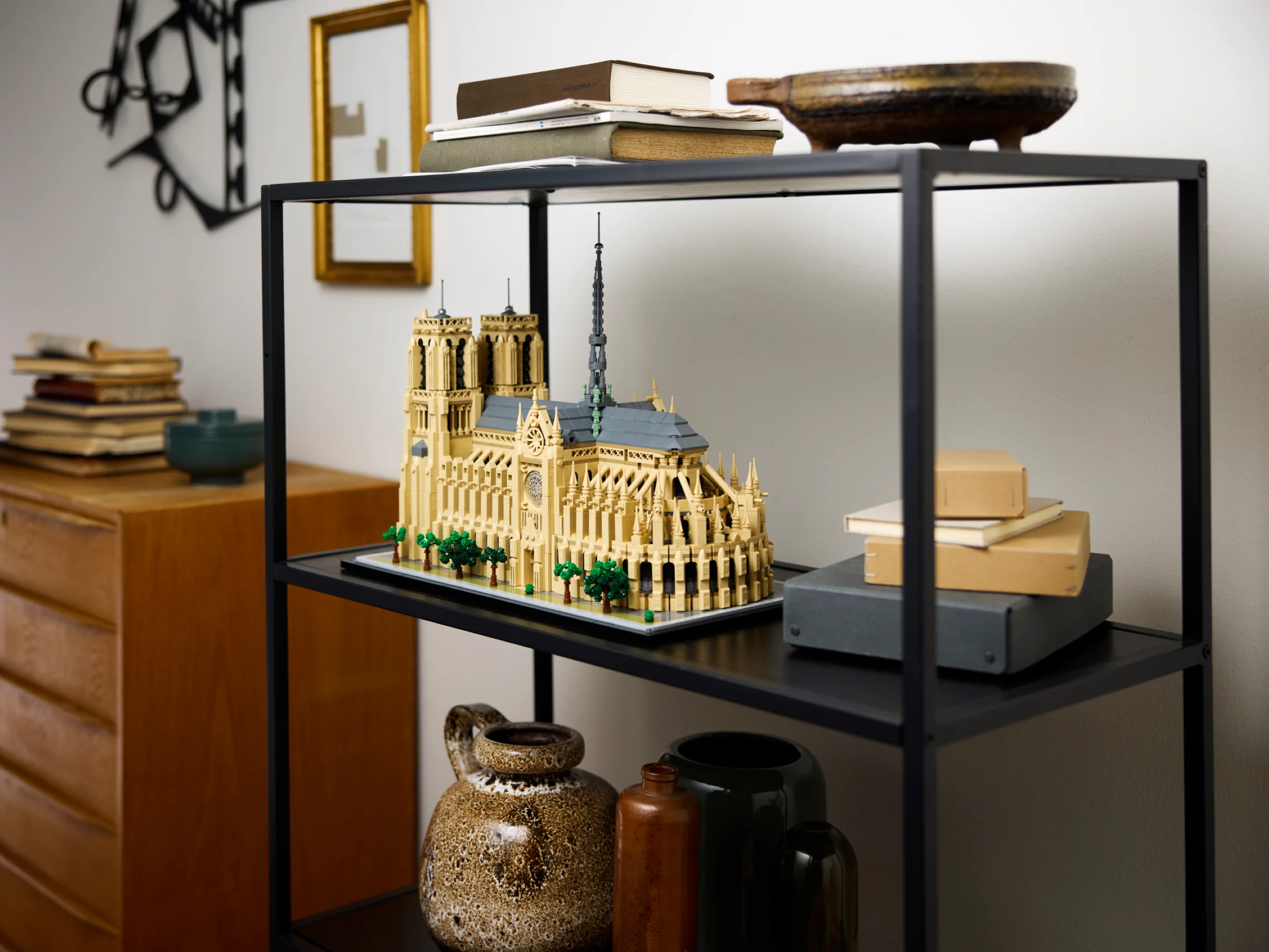 Modelul LEGO Notre-Dame de Paris expus pe un raft modern, alături de cărți și obiecte decorative.