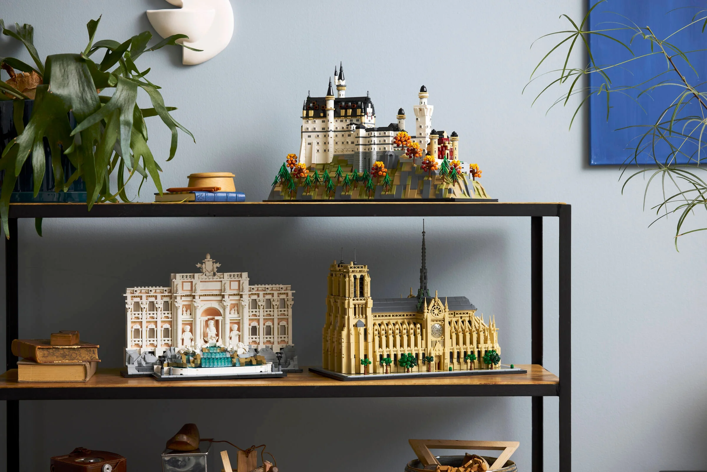 Castelul Neuschwanstein LEGO, alături de alte modele Architecture, expus pe un raft elegant. O imagine demnă de un colecționar.