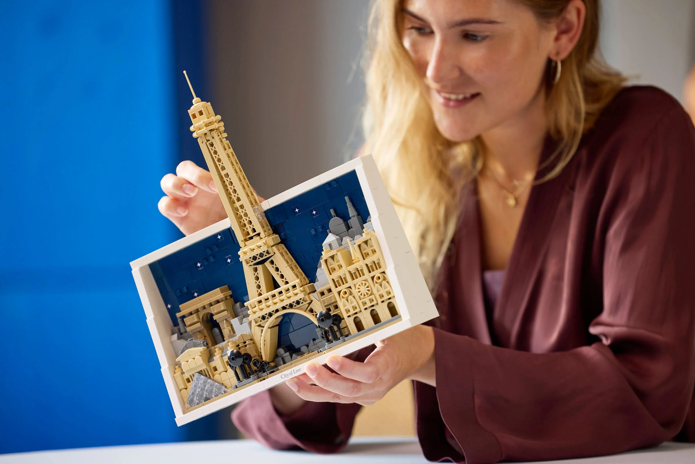 O femeie admiră macheta LEGO Paris, ce include Turnul Eiffel și alte monumente emblematice.