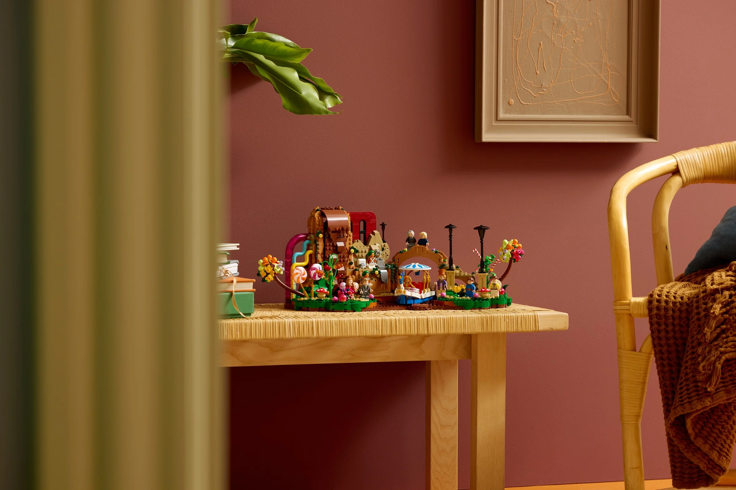 Modelul LEGO Willy Wonka, prezentat pe o masă de lemn, într-un cadru ambiant.