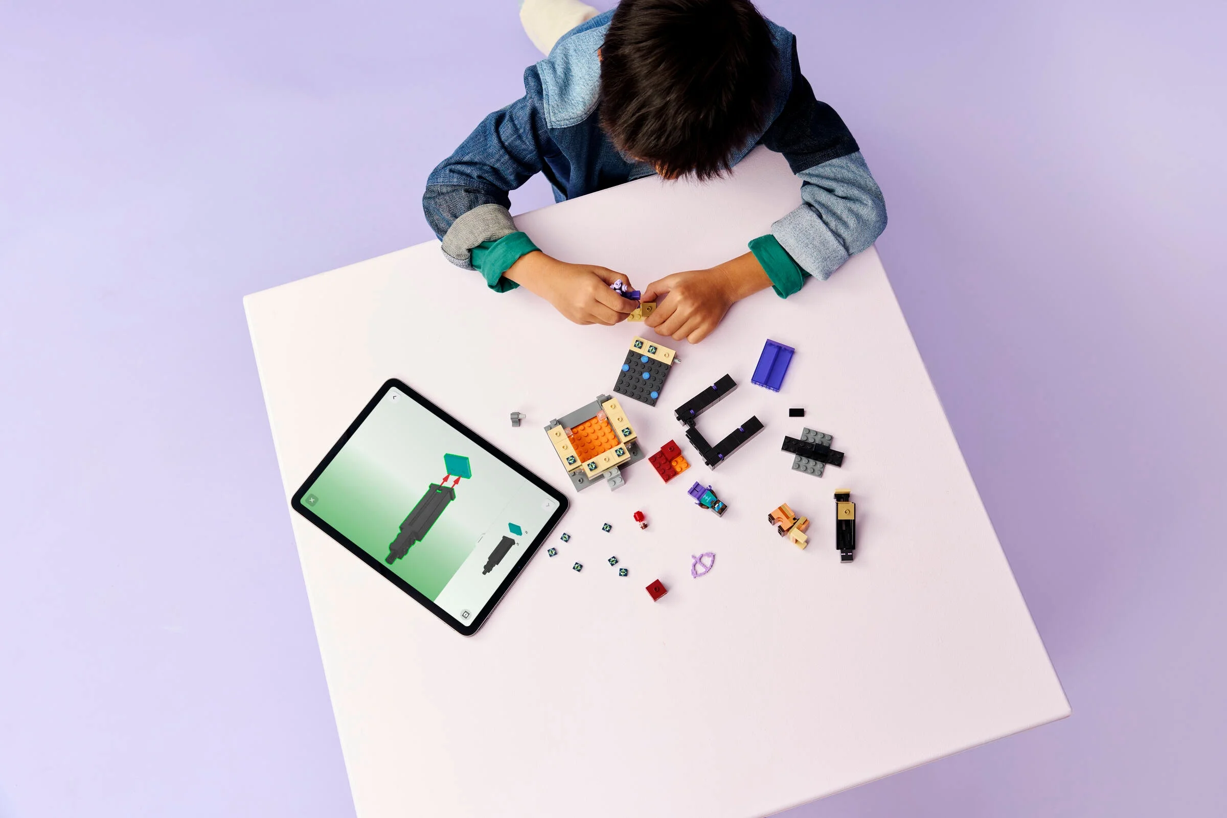 Copil construind setul LEGO Minecraft Nether & End Portal Journey, folosind instrucțiuni digitale.