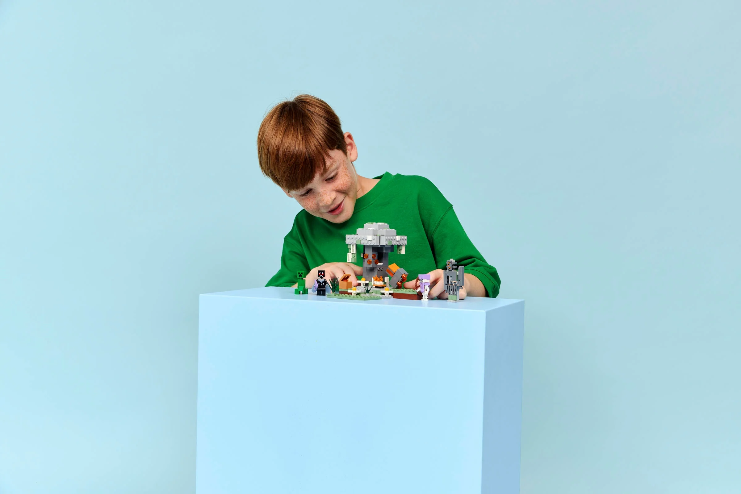 Copil interacționând cu setul LEGO Minecraft 21586, Grădina Pale. Setul include minifigurine și elemente construibile.