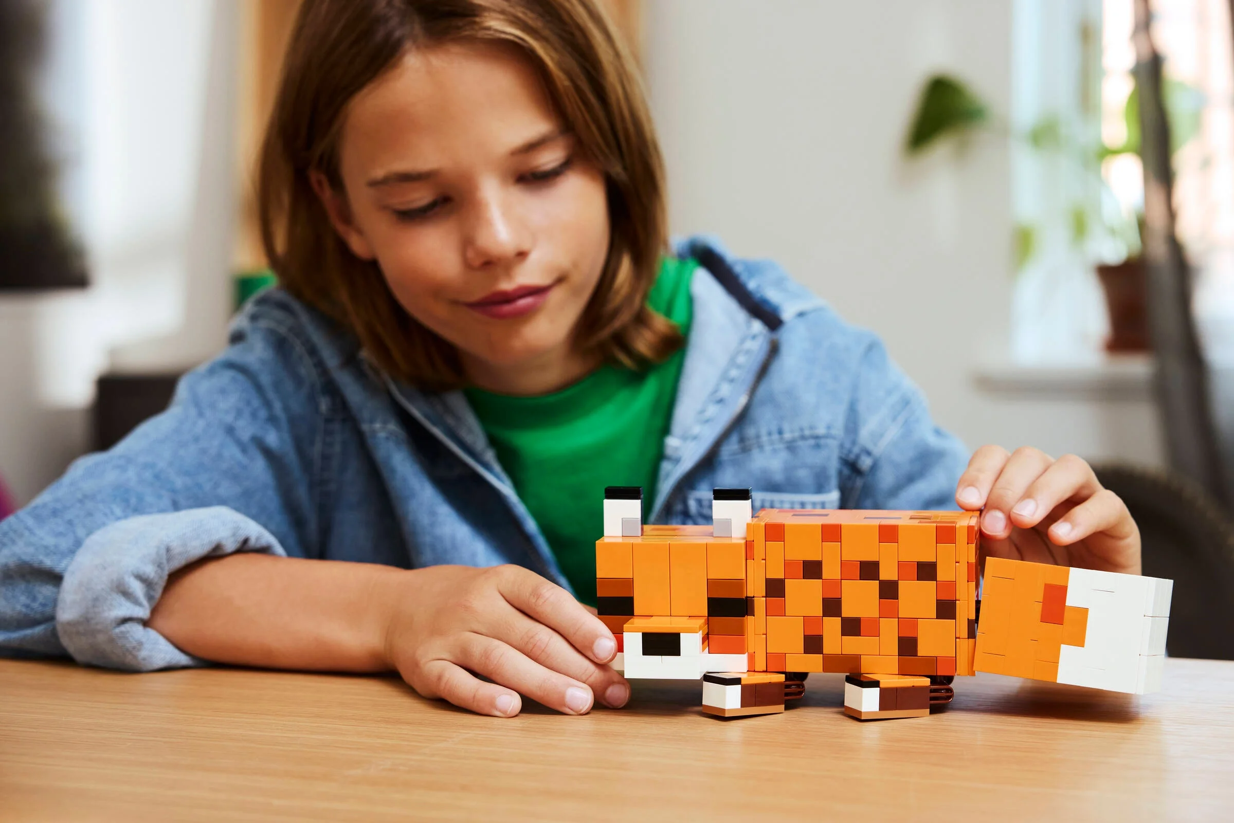 Copil asamblând vulpea LEGO Minecraft. Distracție creativă cu setul LEGO.