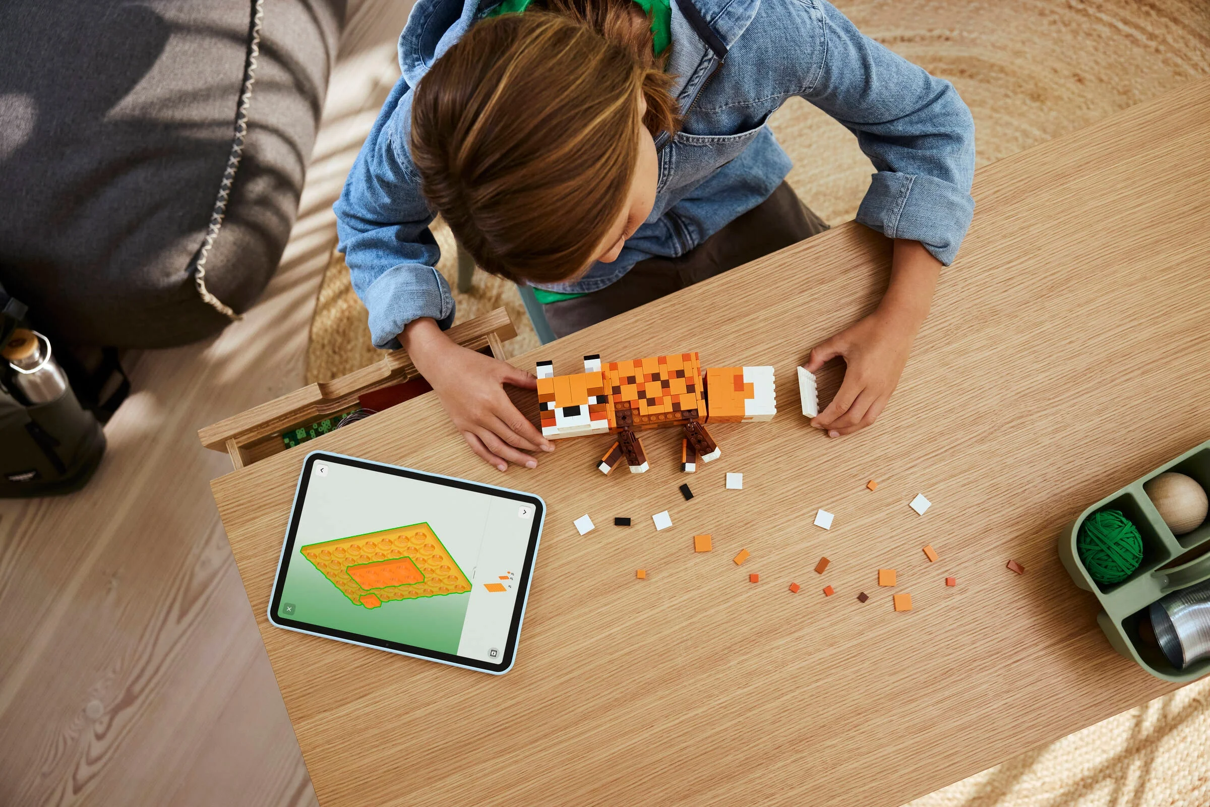 Copil construind vulpea LEGO Minecraft. Vedere de sus, detaliată și atrăgătoare.