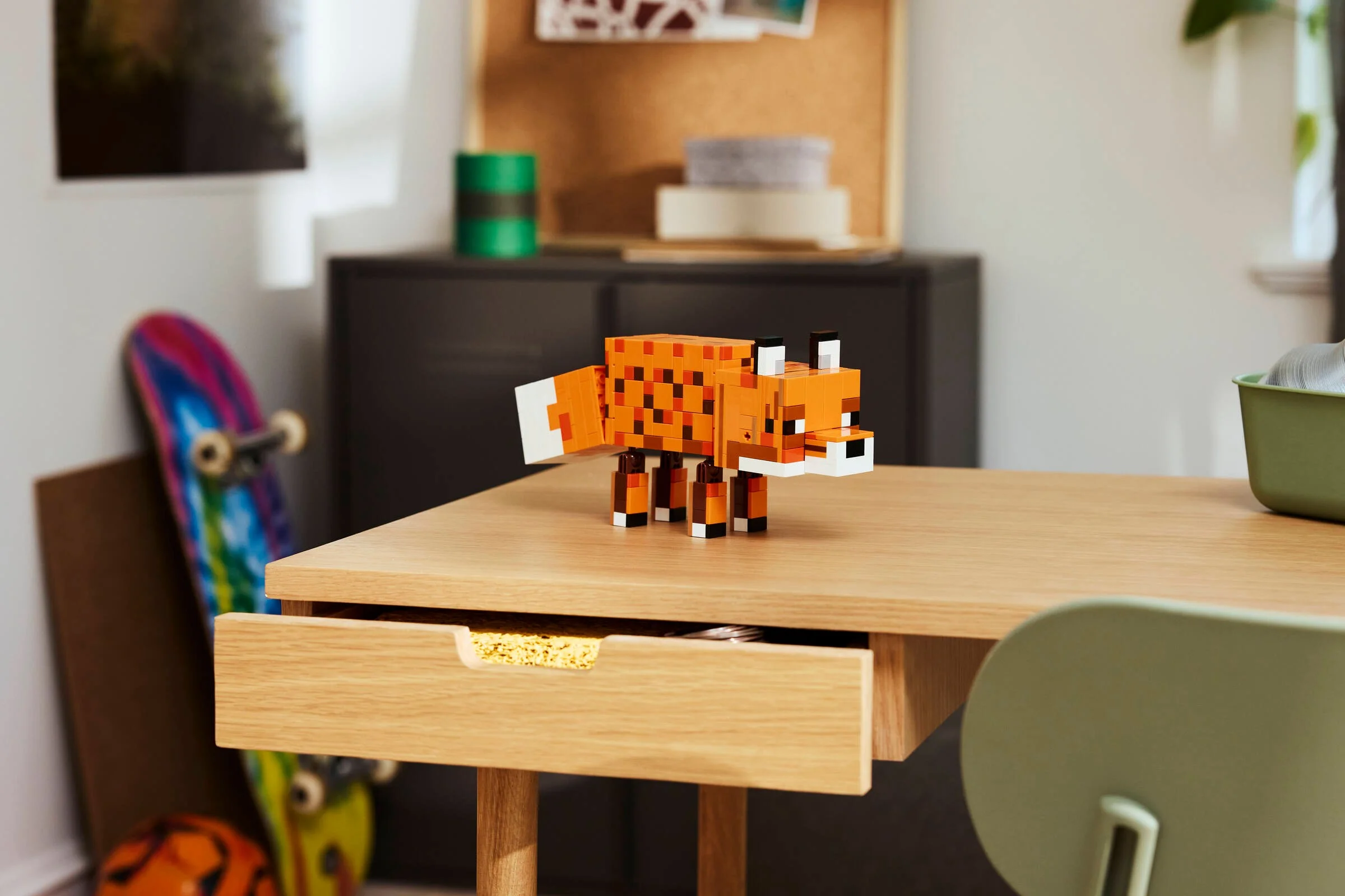 Vulpea Minecraft LEGO stă pe un birou ordonat, într-o cameră luminoasă. Jocul prinde viață!