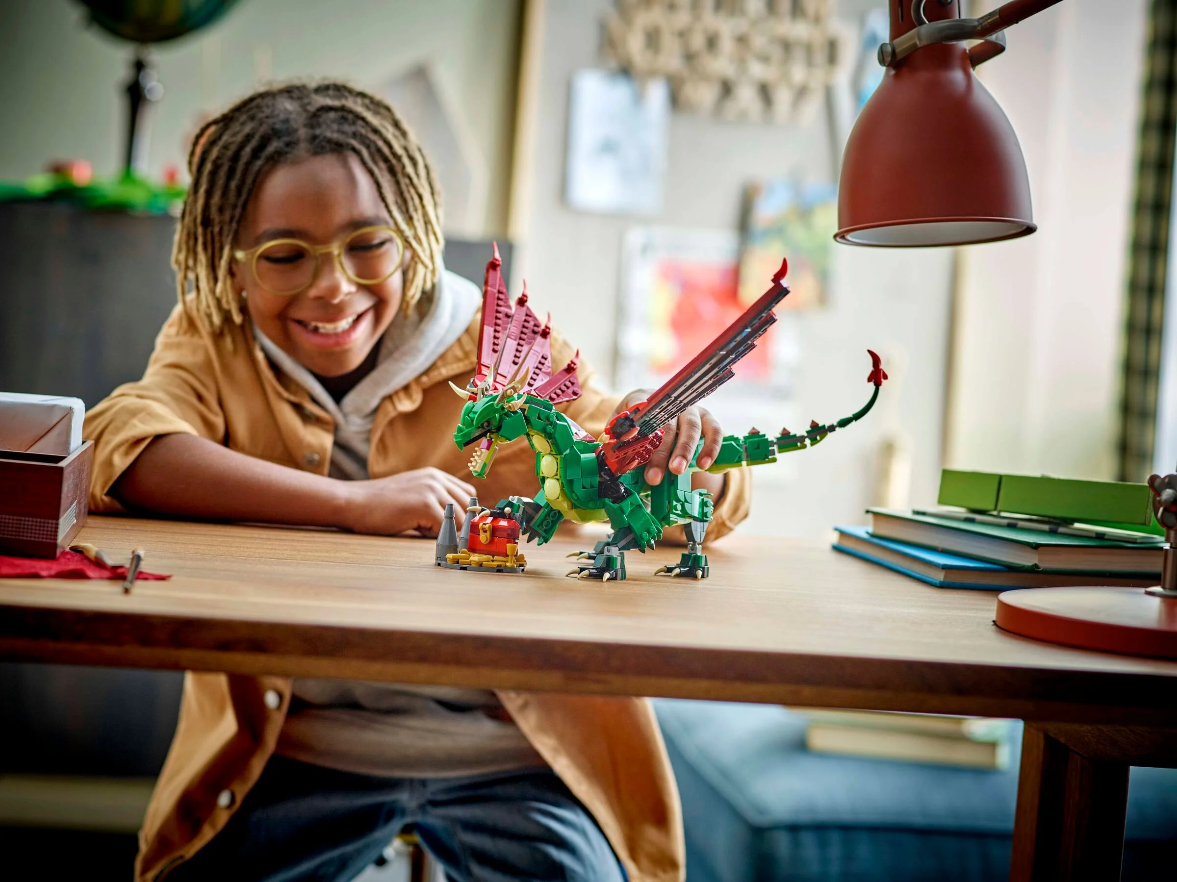 Copil zâmbitor se joacă cu dragonul medieval LEGO Creator 3în1.