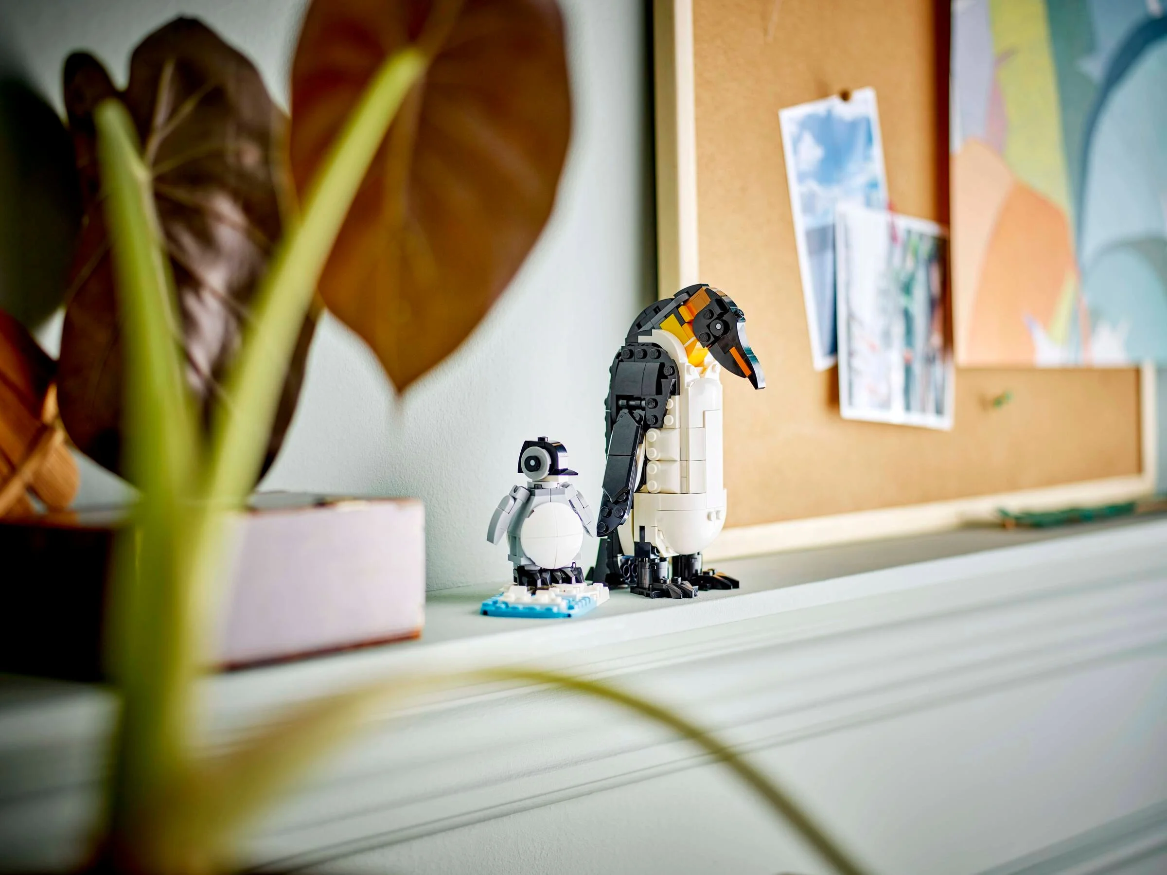 Imagine cu familia de pinguini LEGO 31165, așezată pe o poliță, într-un decor interior.