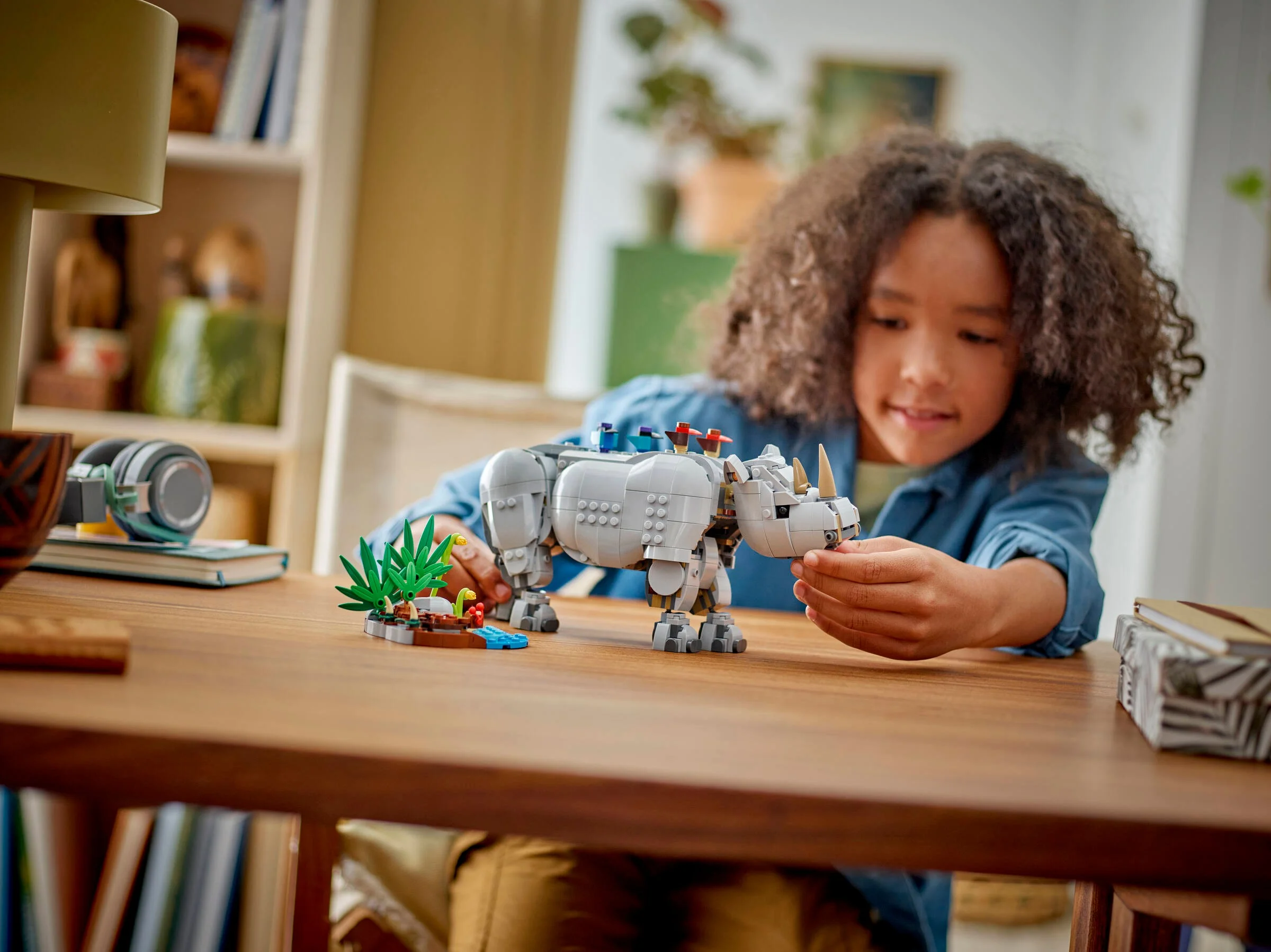 Copil se joacă cu rinocerul LEGO Creator 31171, explorând detaliile și aspectul modelului finit.