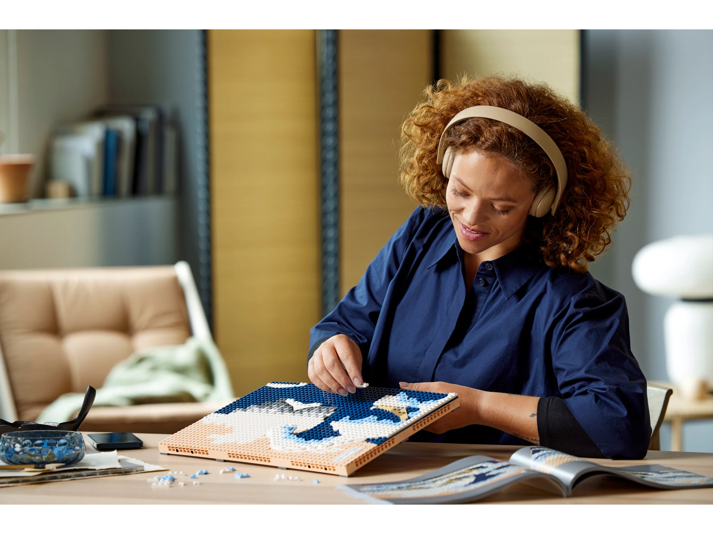Femeie construind mozaicul LEGO Hokusai. Concentrare și relaxare la construcție.