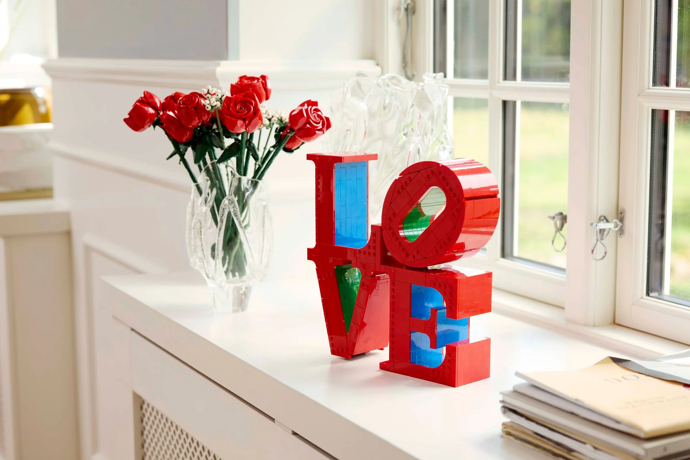 Modelul LEGO LOVE 31214 expus lângă un buchet de trandafiri, într-o ambianță luminoasă și caldă.