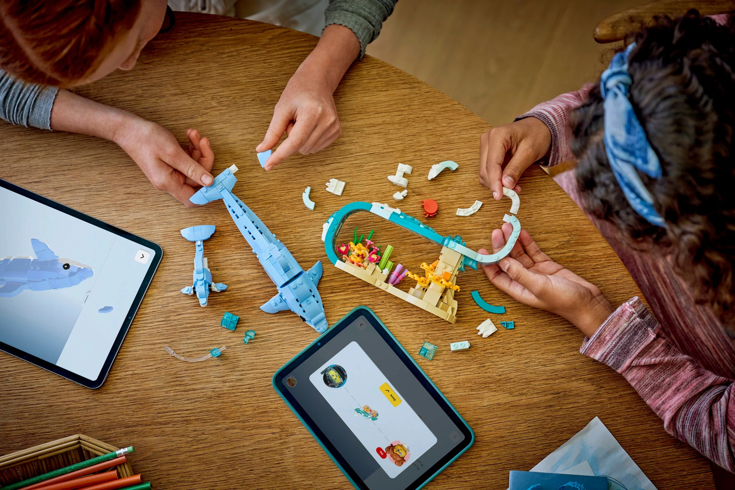 Copii construind setul Delfini Frumoși folosind instrucțiuni digitale.