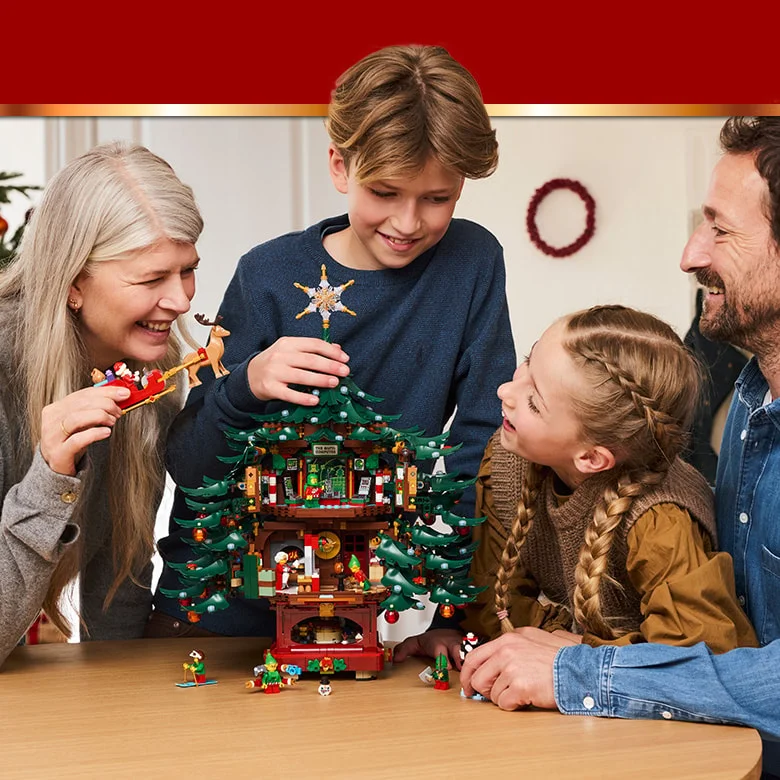 Familie construind și admirând bradul LEGO de Crăciun, plin de detalii festive și minifigurine.