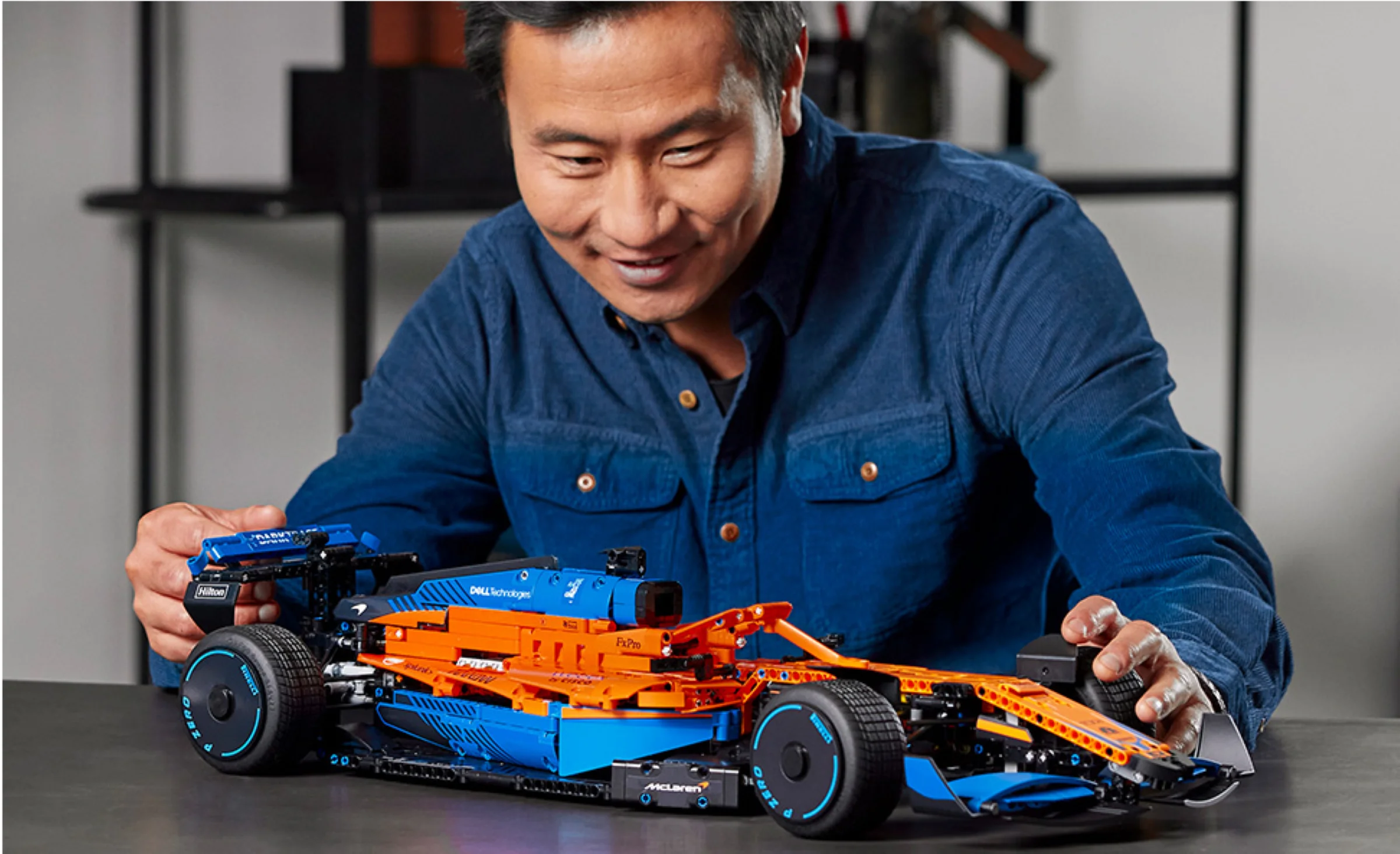 Bărbat admirând mașina de curse McLaren Formula 1 LEGO Technic 42141.
