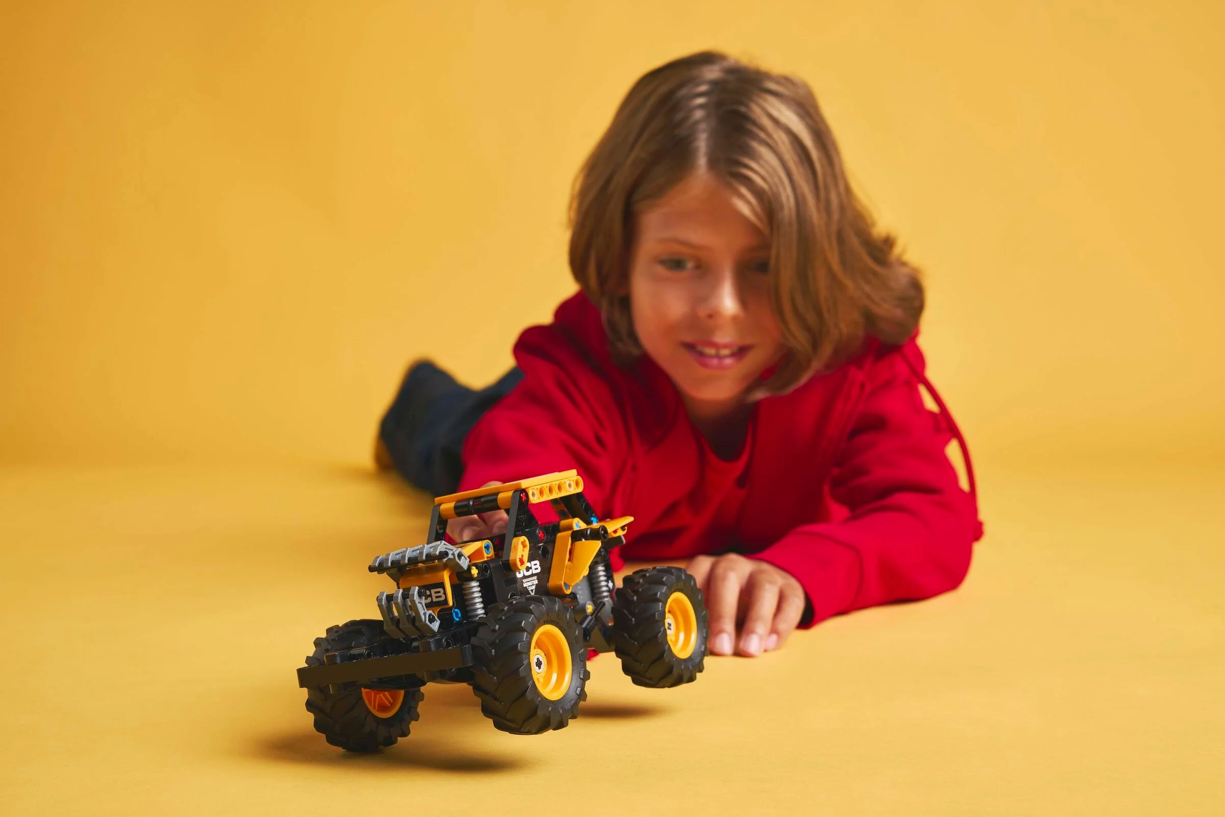 Copil se joacă cu Monster Jam DIGatron. Bucurie și entuziasm vizibile.