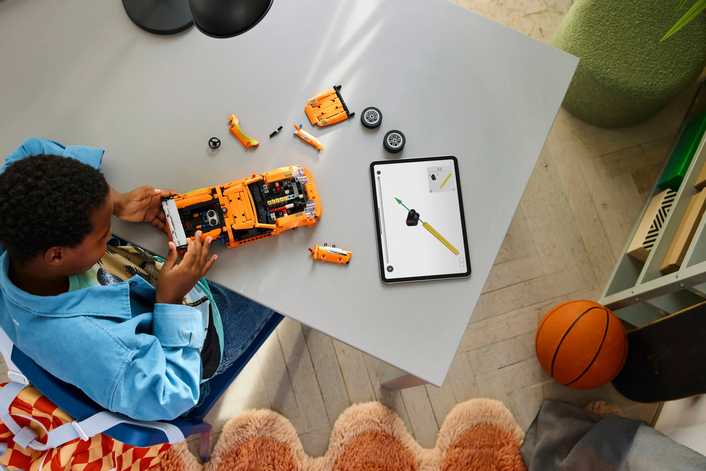 Copil construind Toyota Supra MK4 Technic, folosind instrucțiuni digitale pe tabletă.