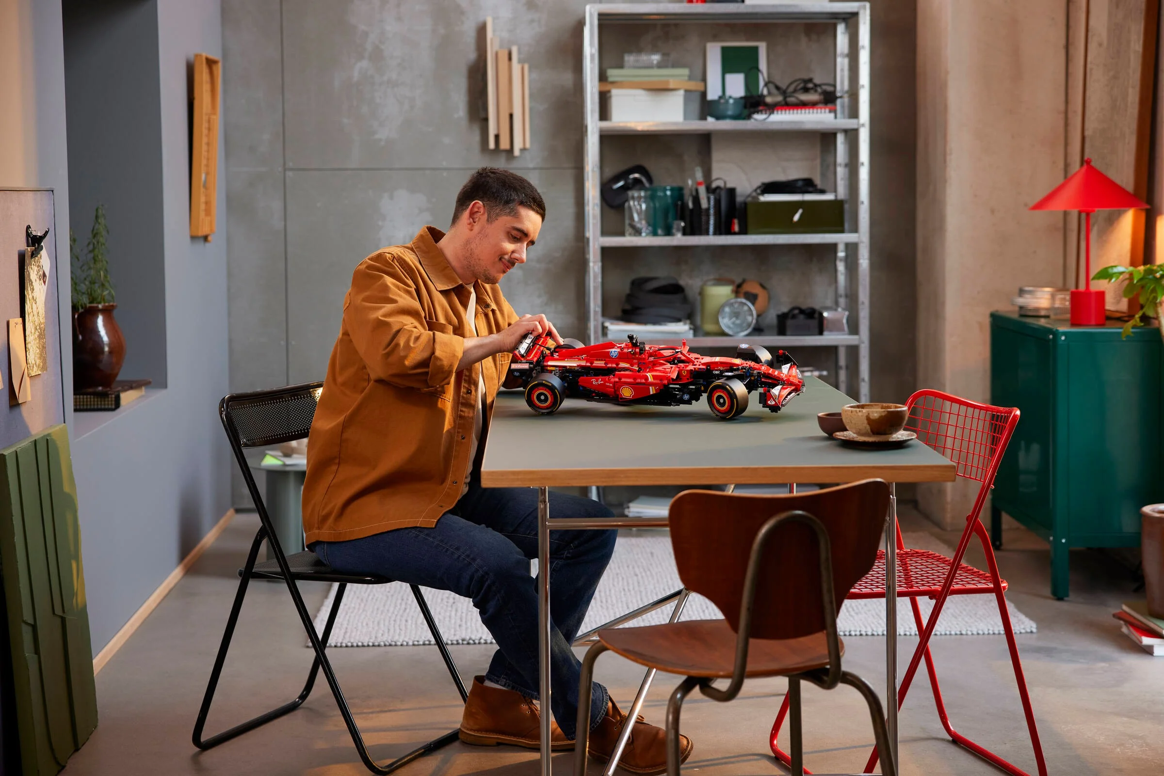Un bărbat asamblând modelul Ferrari SF-24 F1, creând o scenă relaxată.