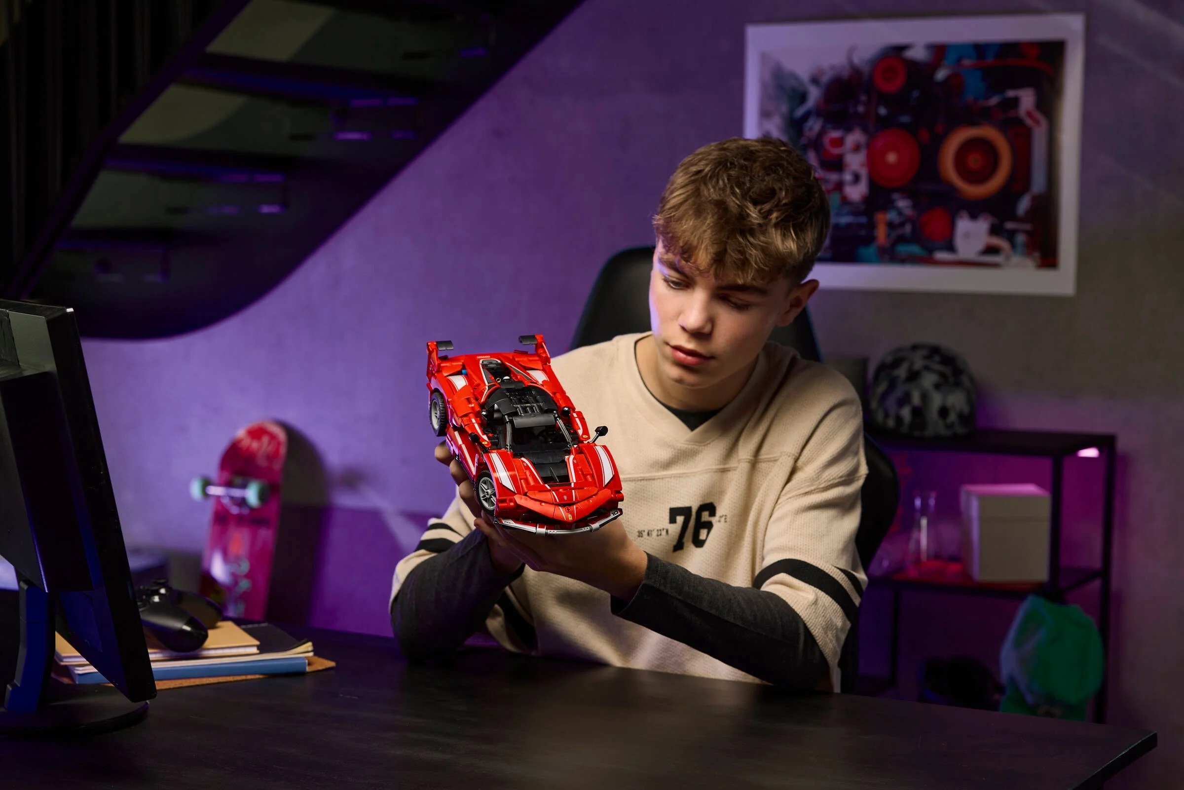 Un adolescent admiră modelul Ferrari FXX K din LEGO Technic, roșu și detaliat.