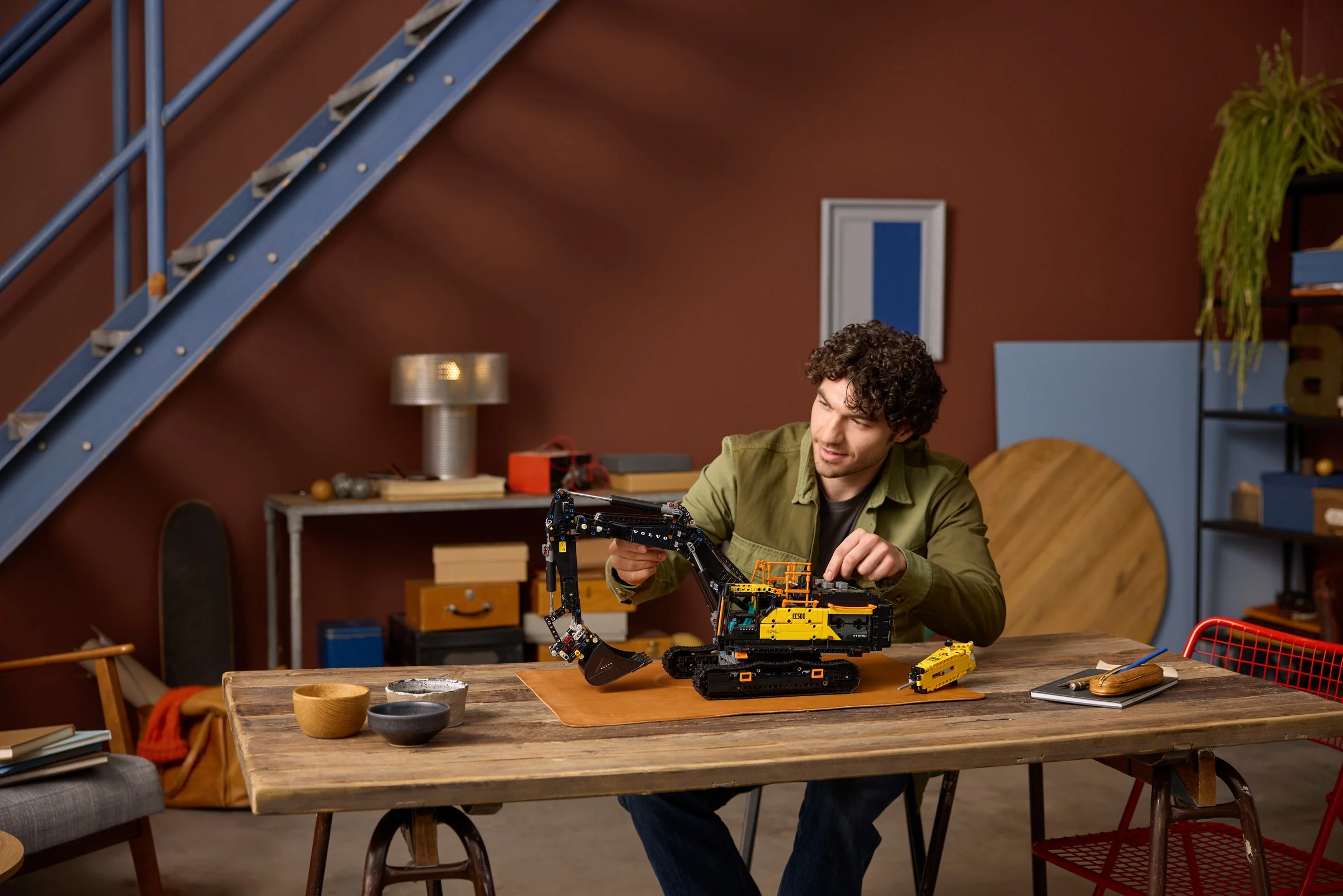Bărbat interacționând cu excavatorul Volvo EC500 Hybrid LEGO Technic.