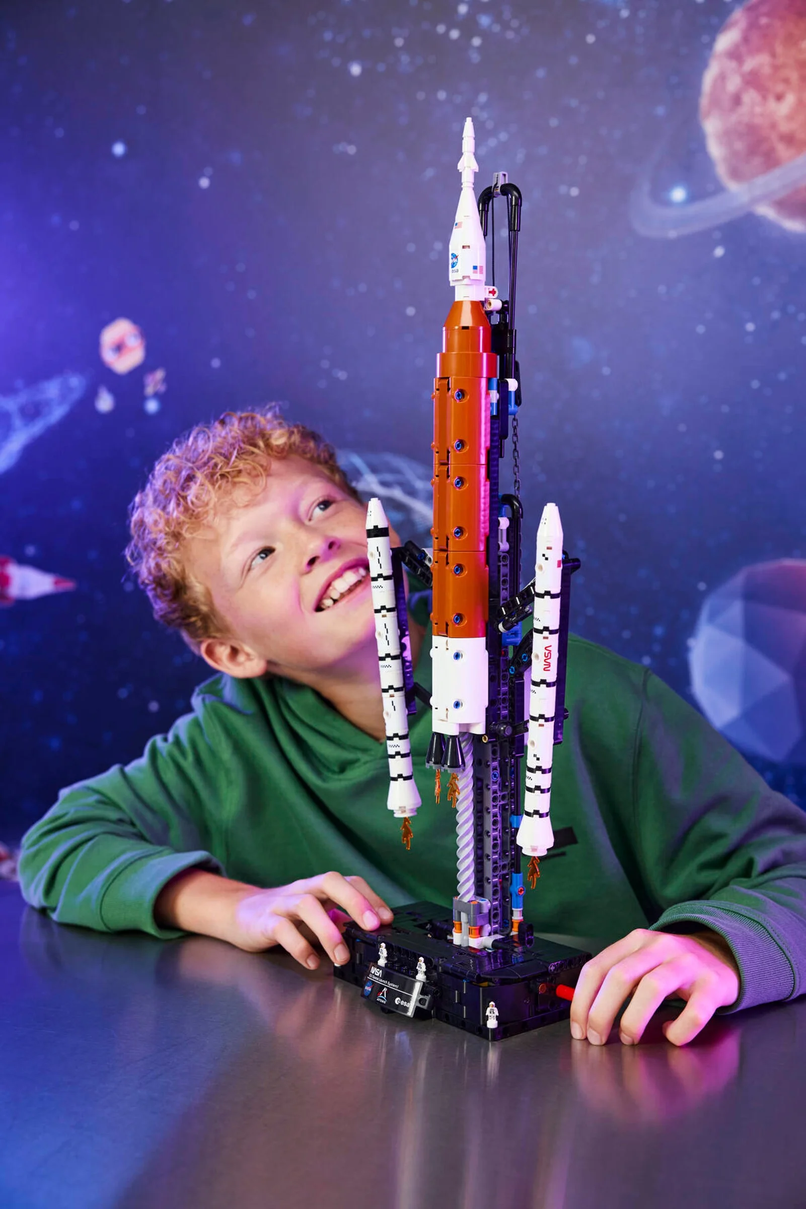 Copil entuziasmat admirând racheta NASA Artemis din setul LEGO Technic 42221.