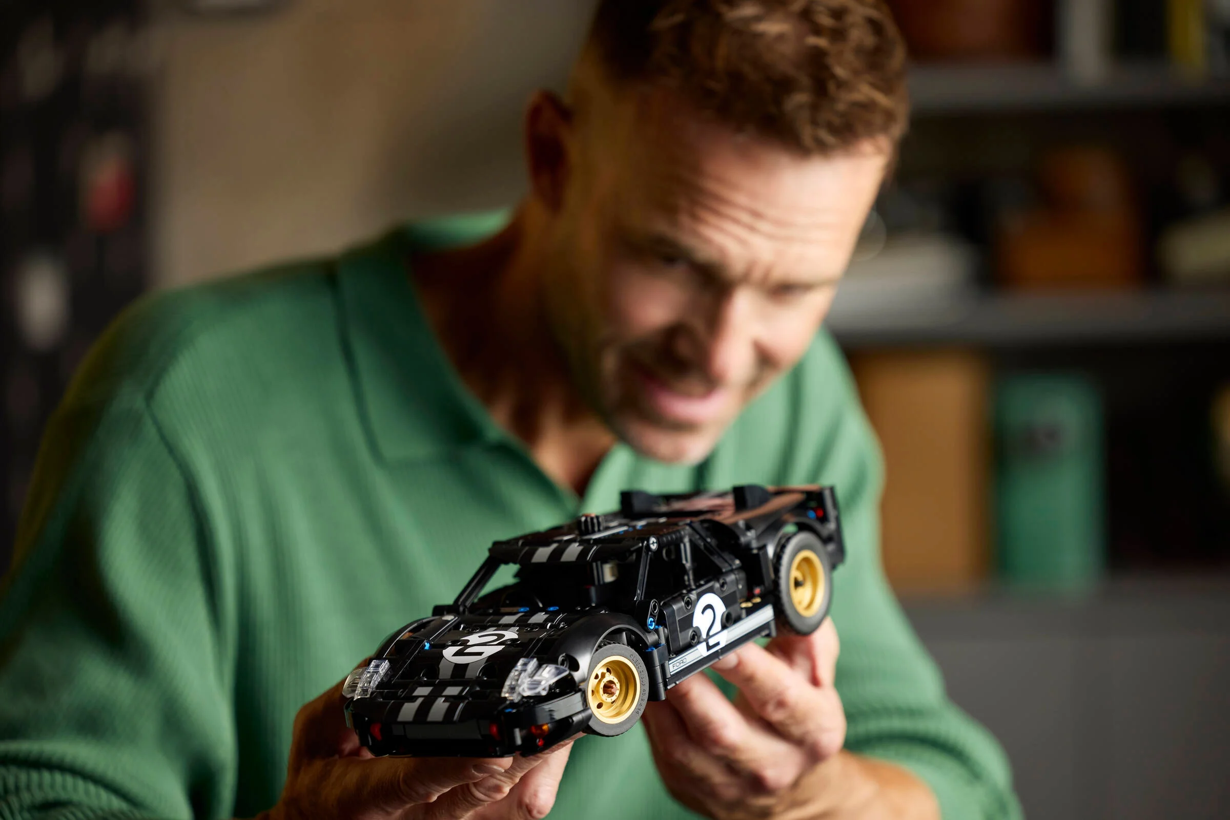 Bărbat admirând modelul Ford GT40 MKII, o construcție LEGO Technic detaliată.