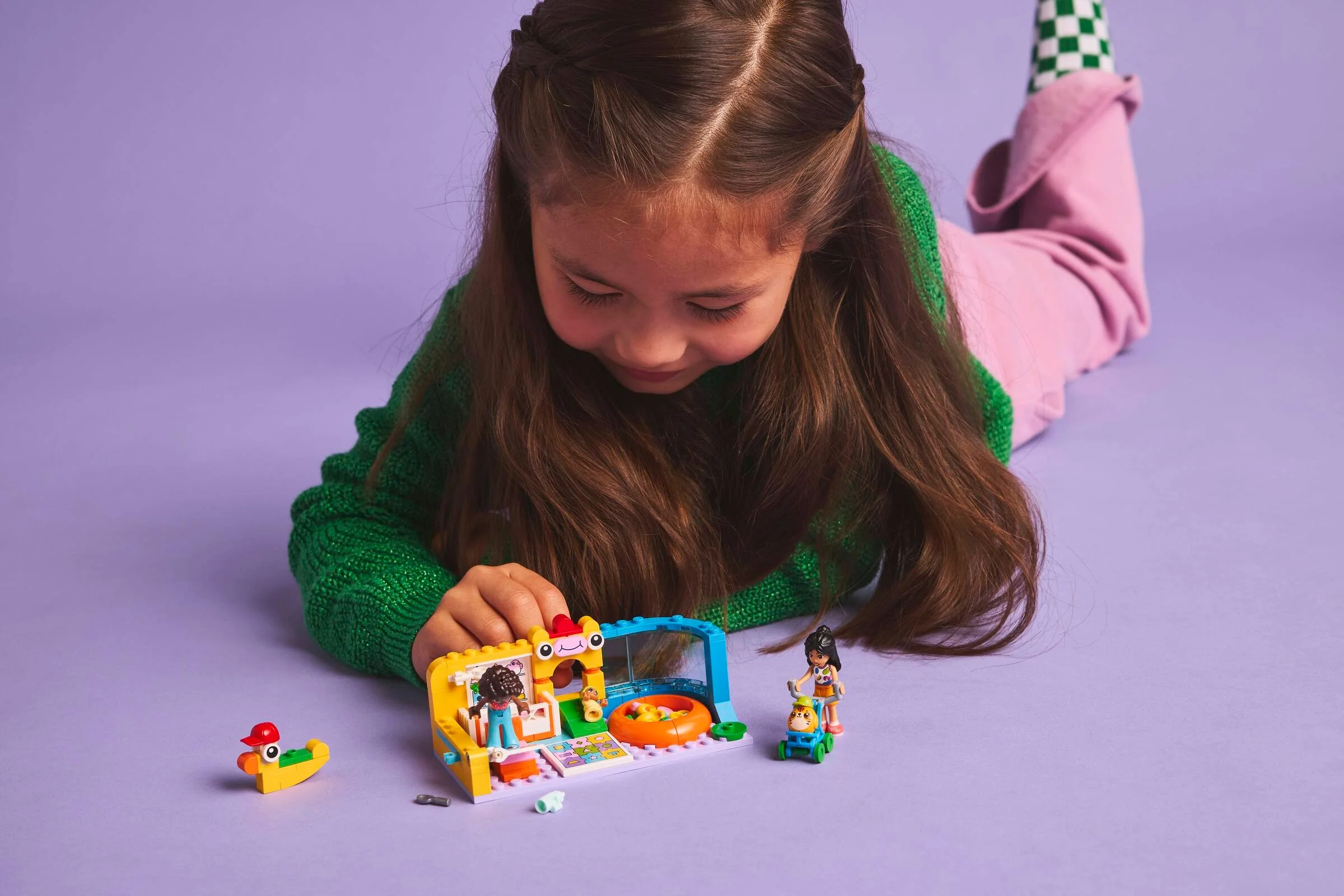 O fetiță se joacă cu setul LEGO Friends 42645, explorând detaliile camerei bebelușului.